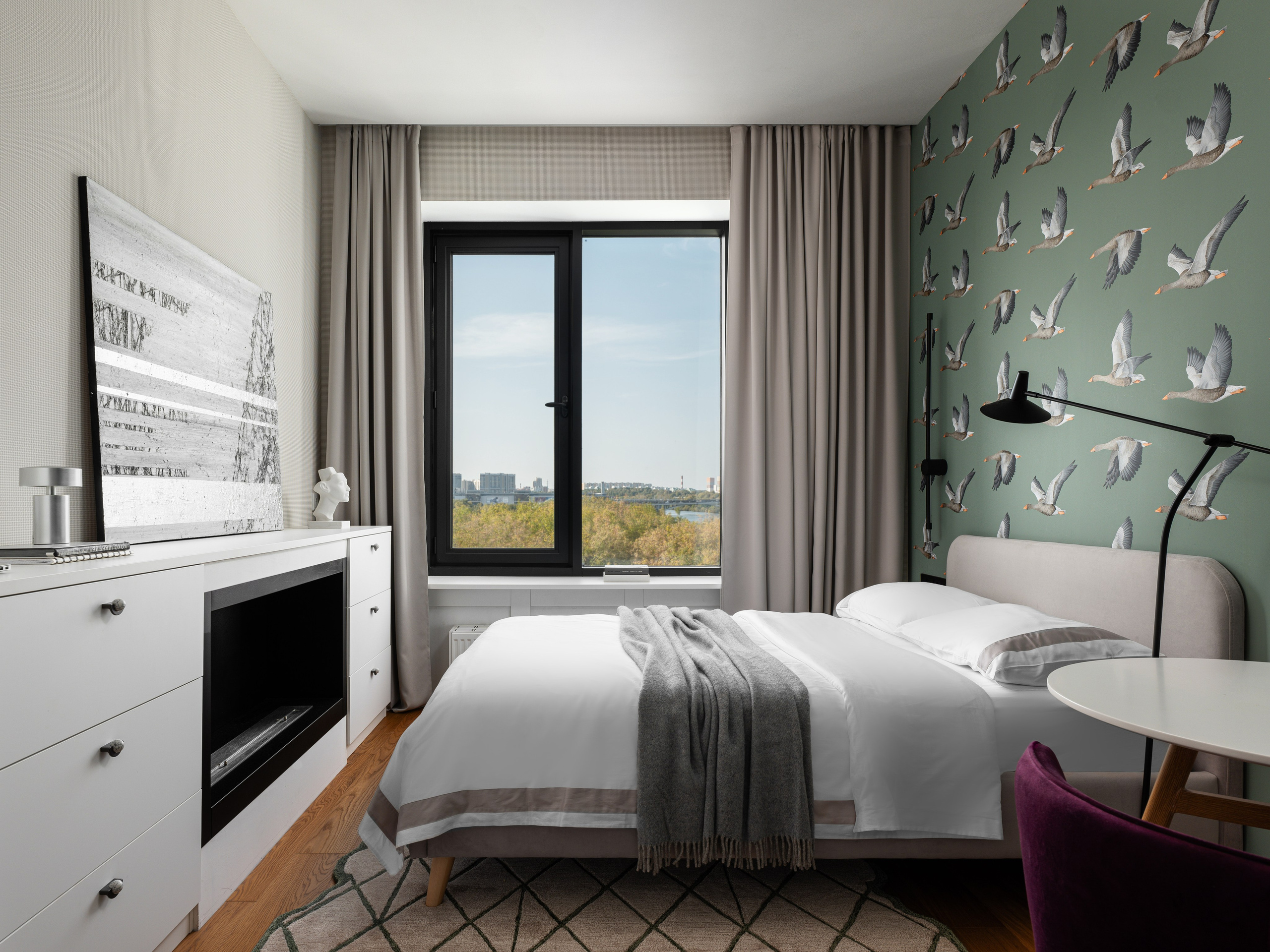 Уютная спальня с большой кроватью и панорамным окном.