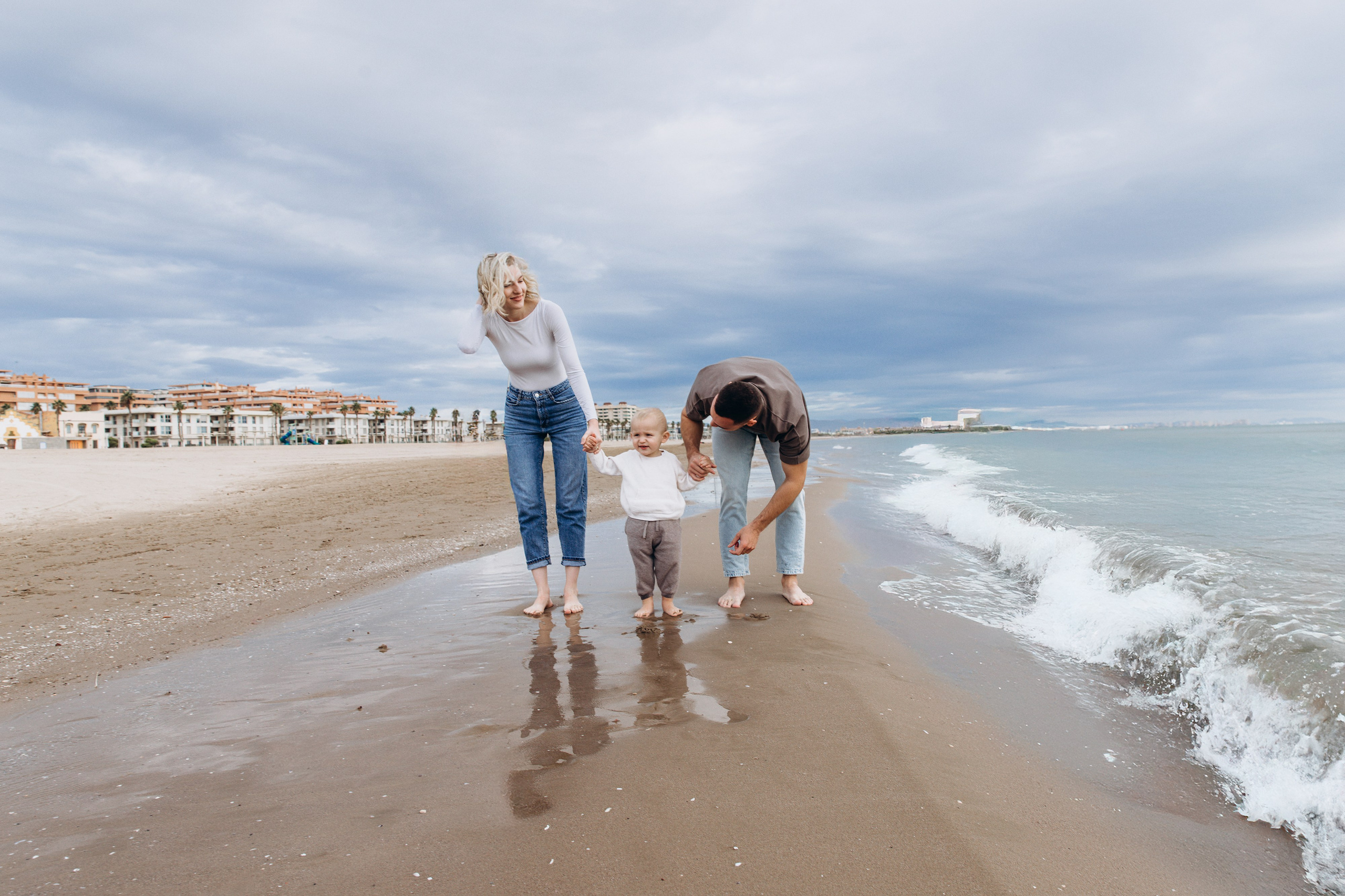 Сімейна фотосесія на пляжі у Валенсії з повсякденним, зручним одягом, яка демонструє, як розслаблені образи допомагають створити природний рух і щирі моменти.