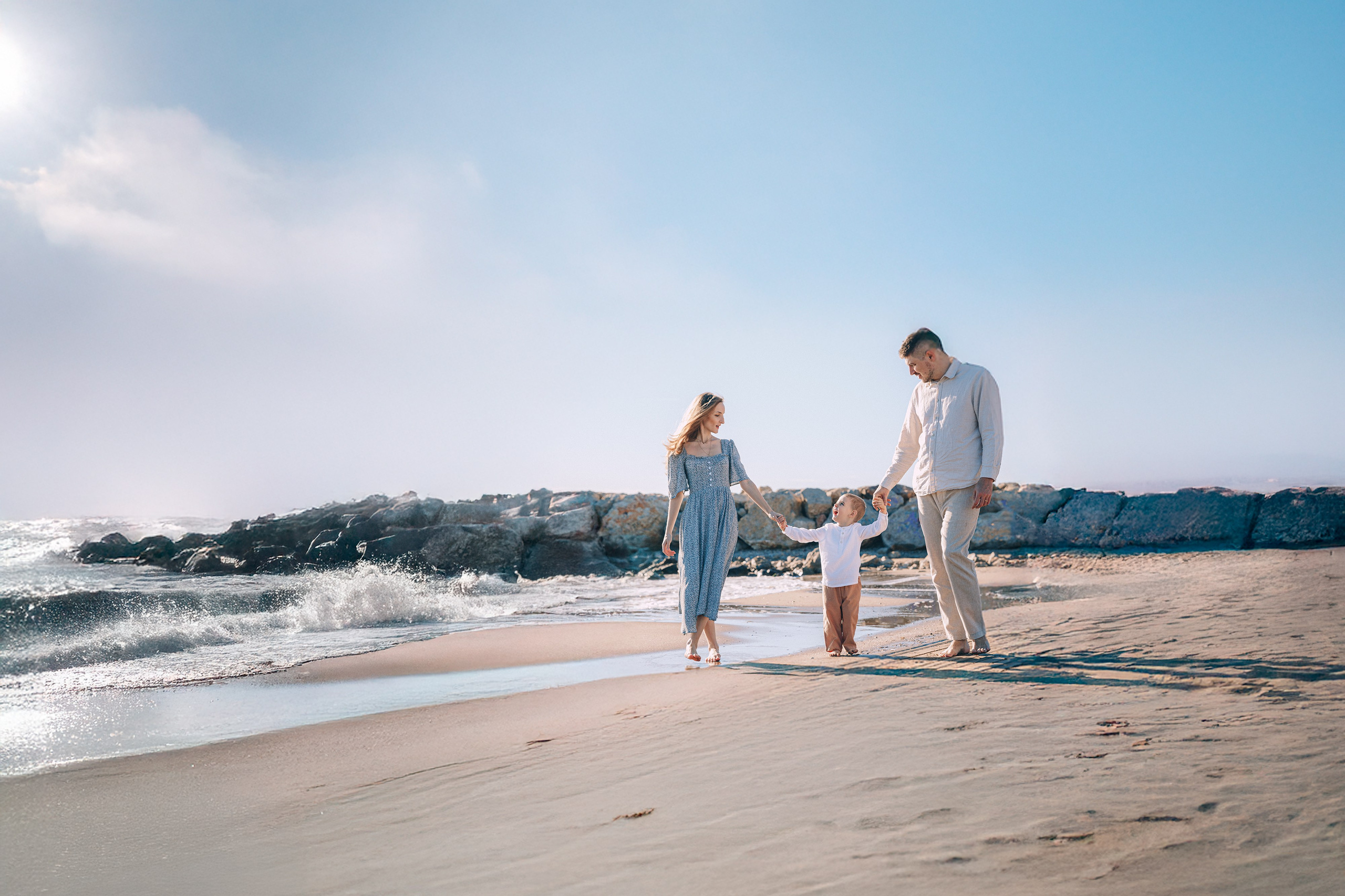 Сімейна фотосесія на пляжі у Валенсії з м’якими нейтральними образами, яка показує, як легкі тканини та спокійні кольори сприяють природному руху й розслабленим моментам з дітьми.