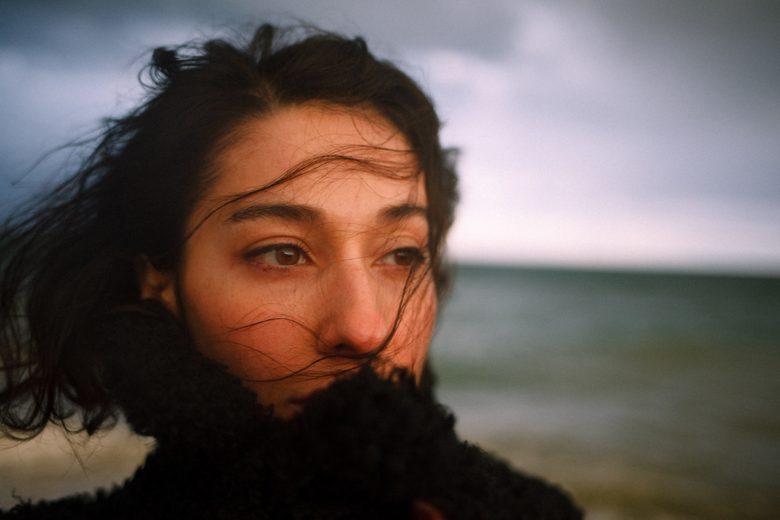 portrait of a woman with wind-blown hair by the sea, Barcelona portrait photographer