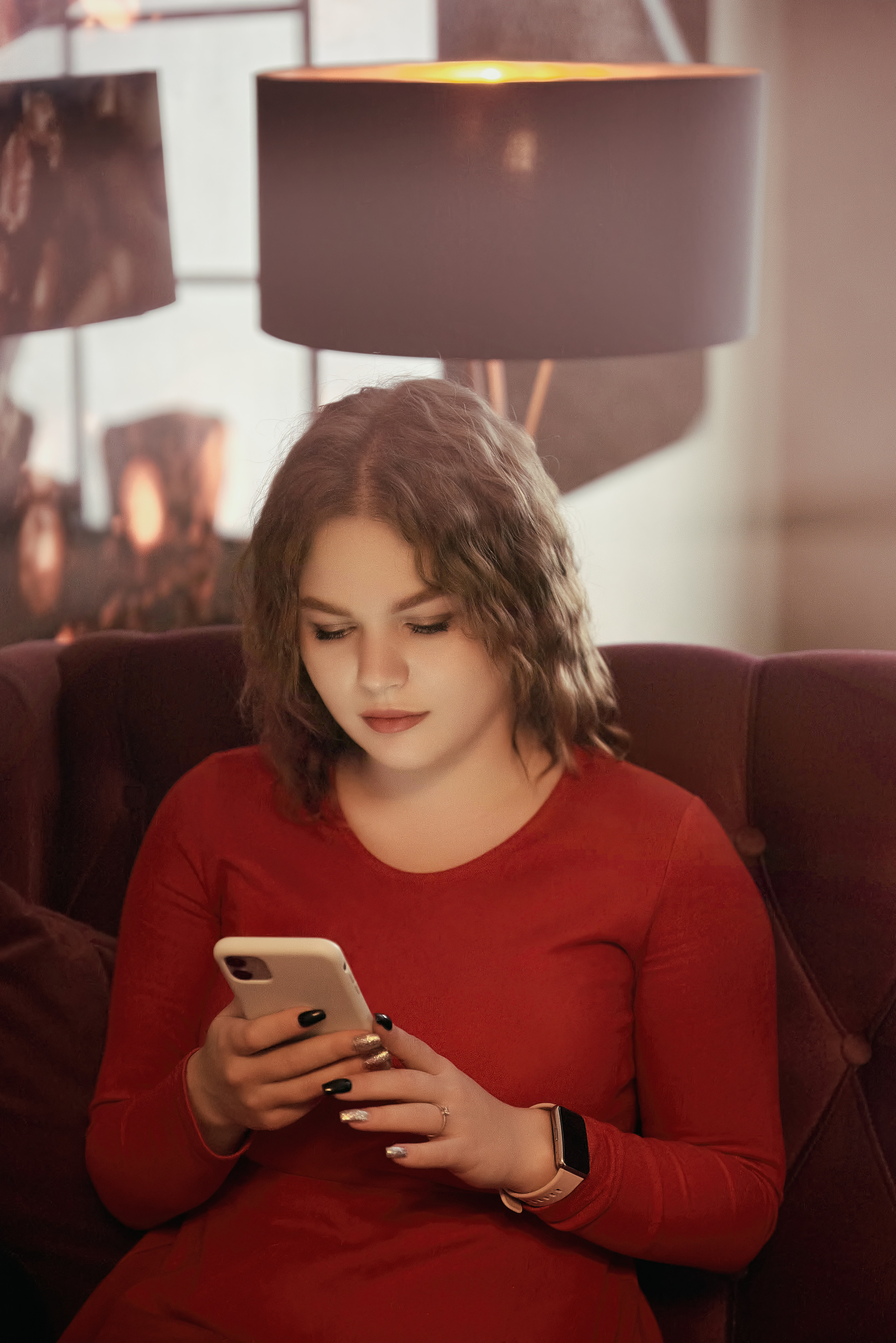 Девушка в кафе чатиться в телефоне.