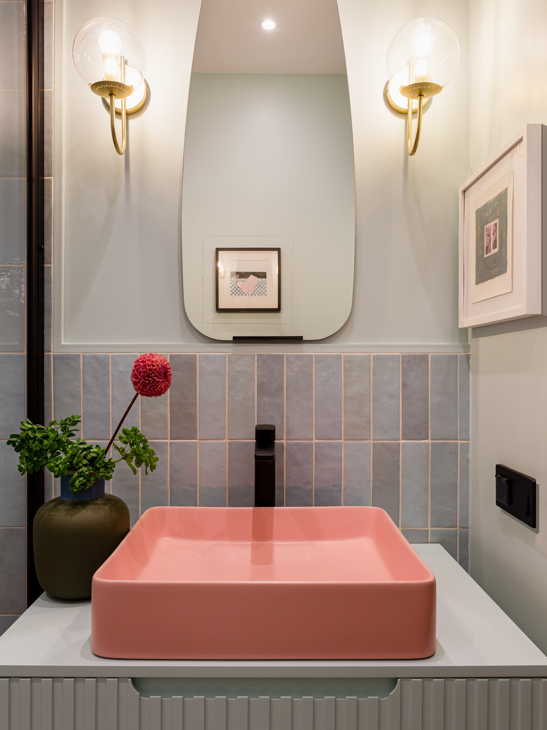 Розовая раковина и черная сантехника в ванной квартиры молодой пары