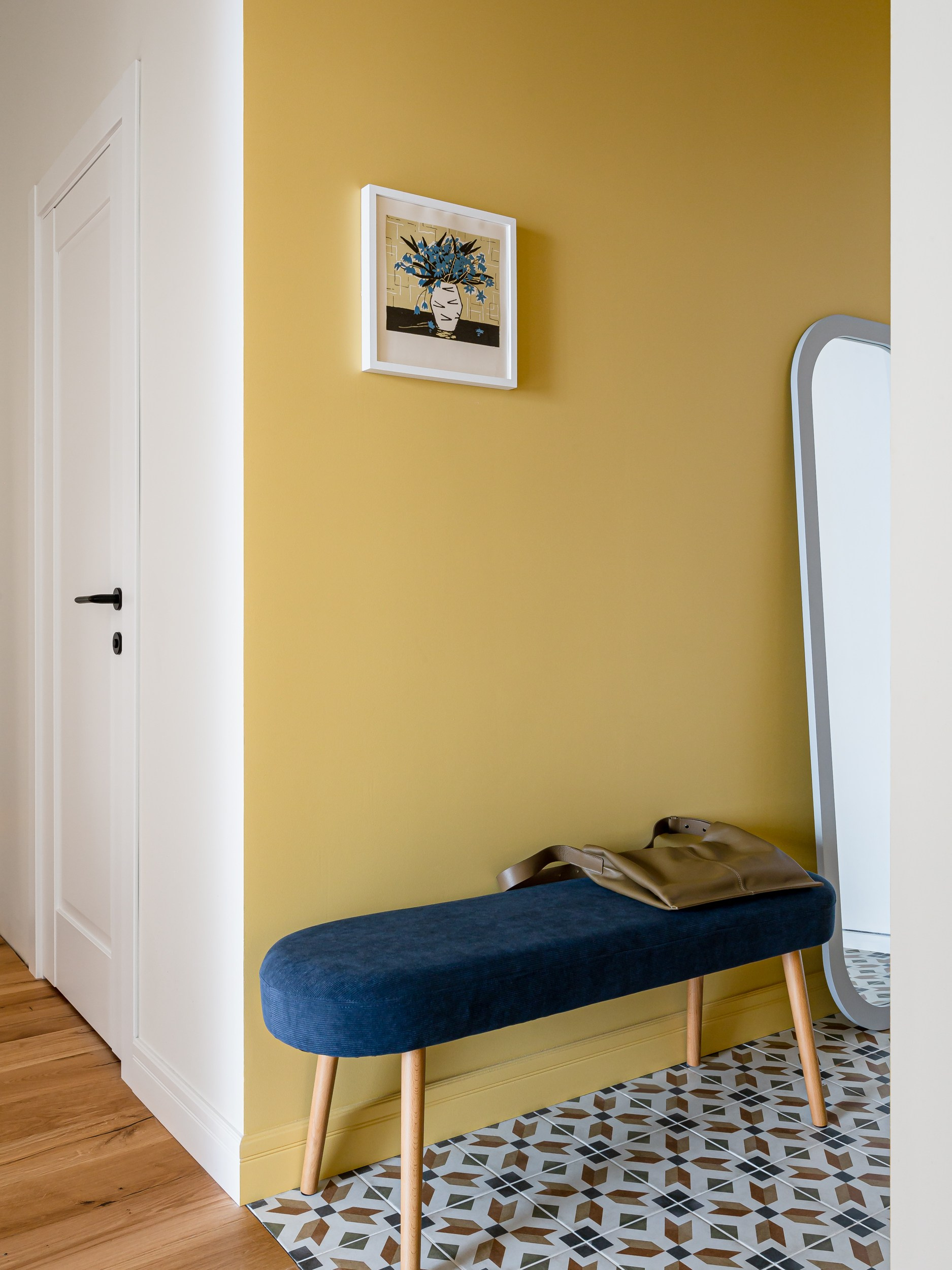 Арочное зеркало и скамья на фоне плитки с цветочным принтом