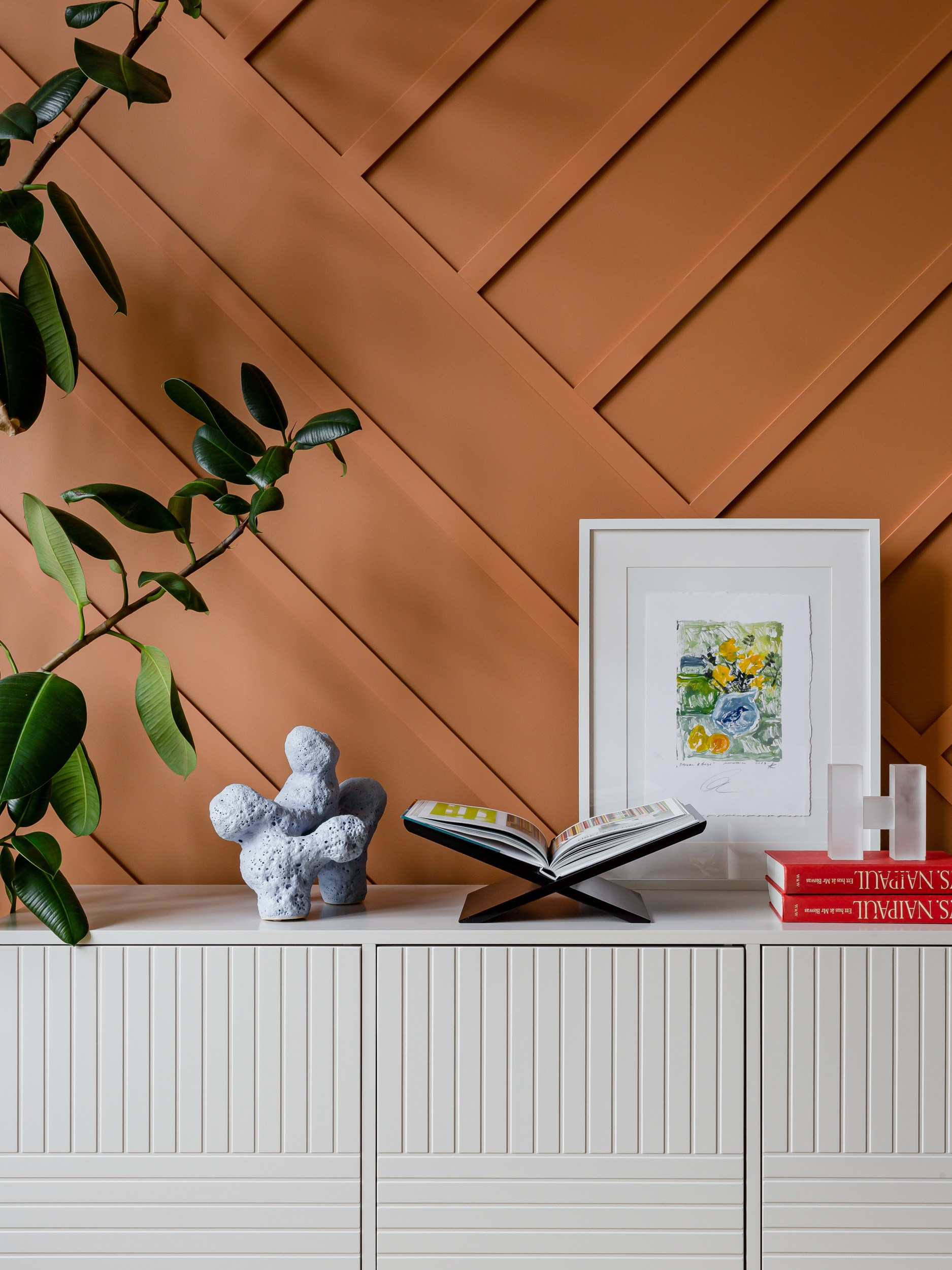 Яркая терракотовая стена с молдингами в дизайне квартиры