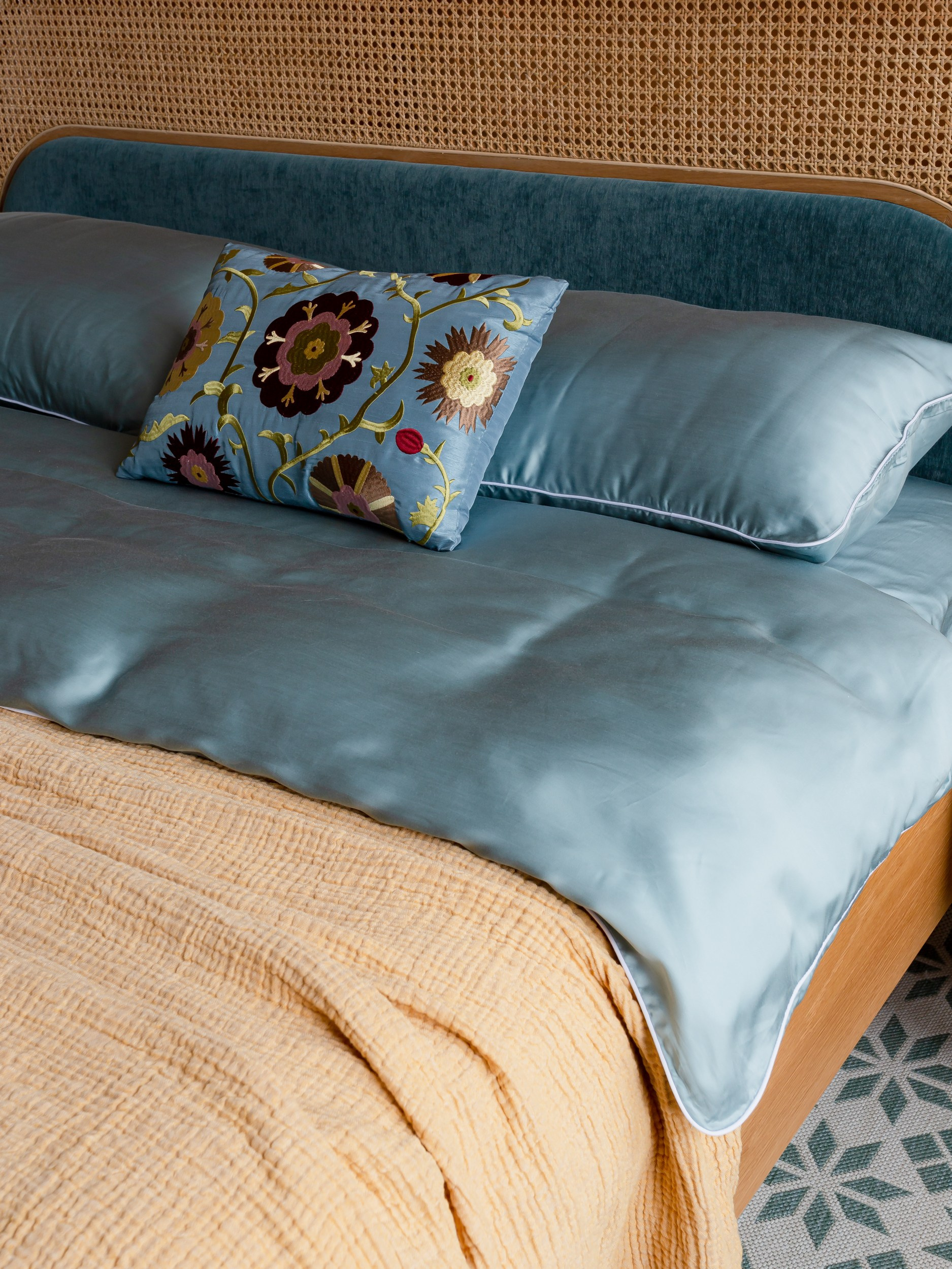 Кровать из ротанга в спальне с яркими желтыми акцентными стенами