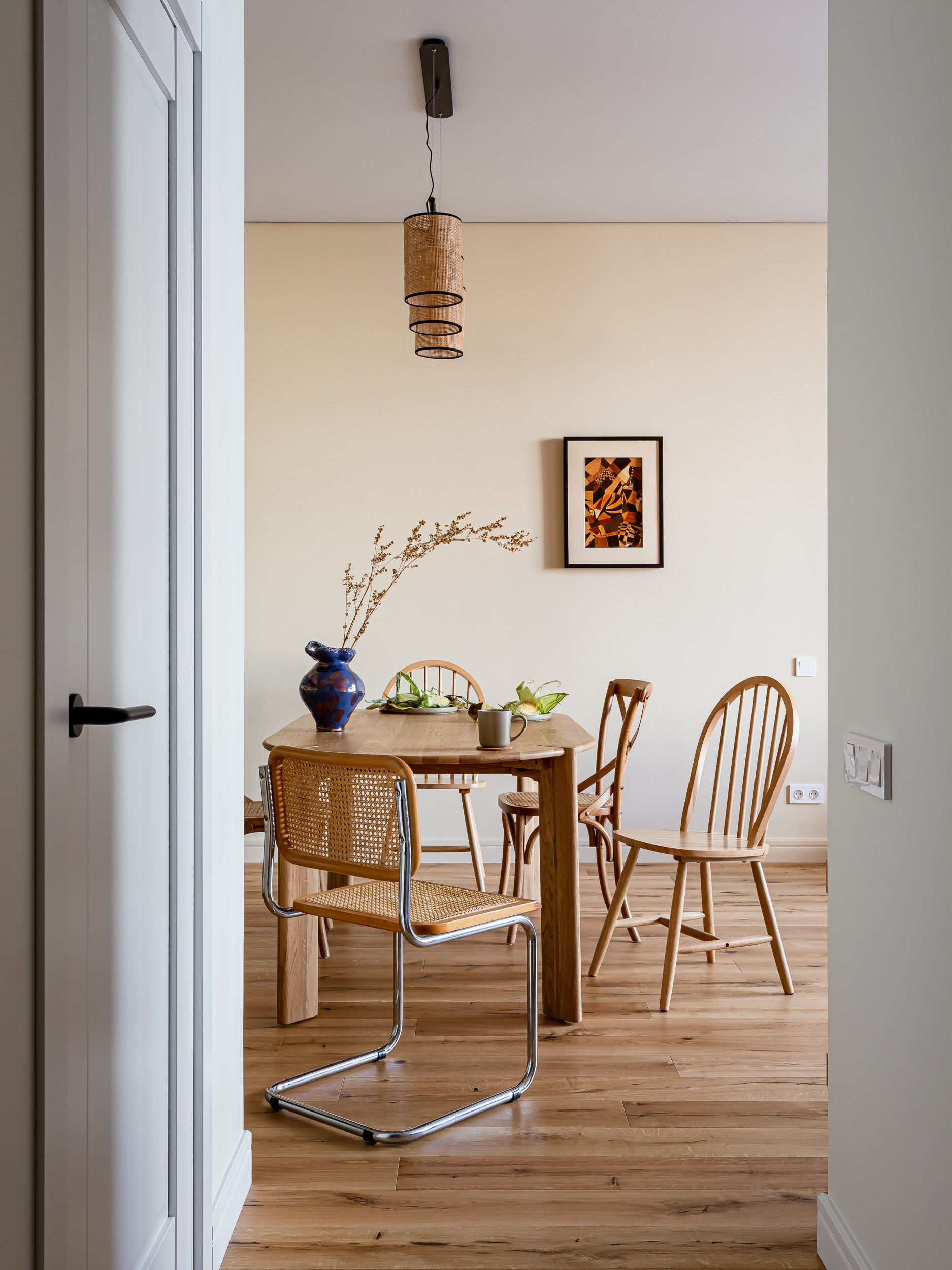 Радиусный дубовый стол и стулья Cesca в уютной ретро кухне молодой пары