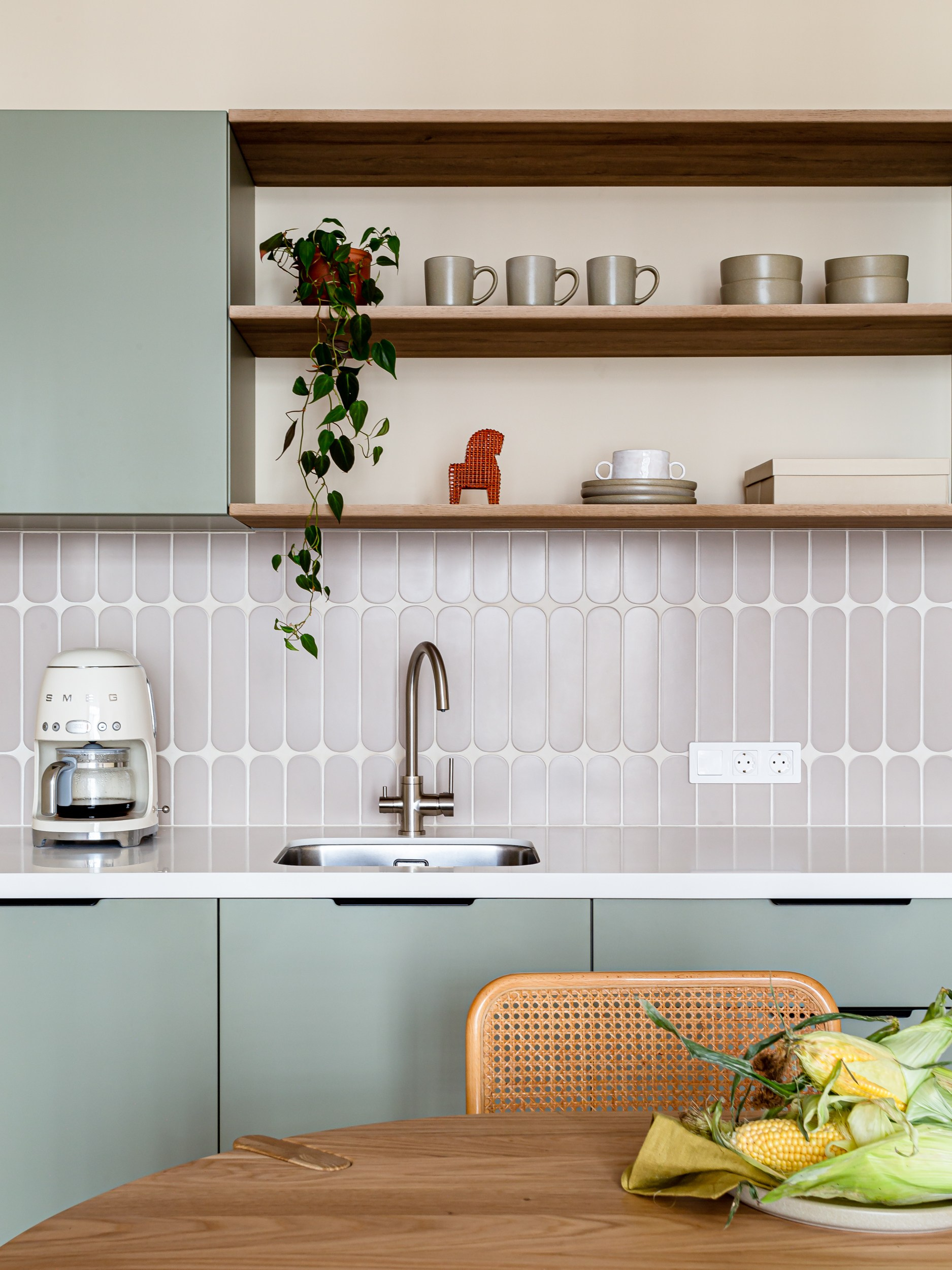 Овальная плитка на фартуке зеленой кухни с винтажными акцентами