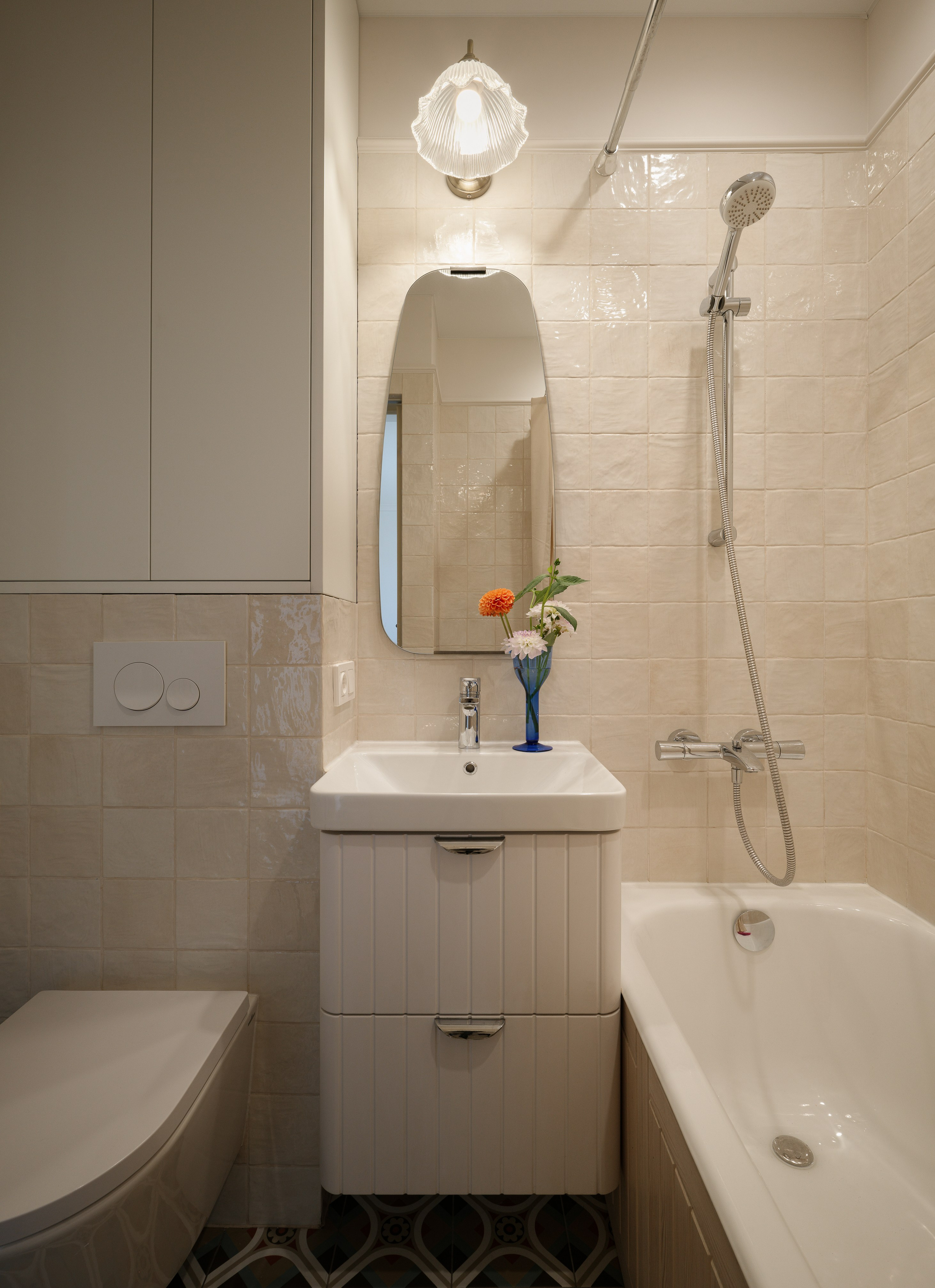 Ванная комната с белой квадратной испанской плиткой и ванной с деревянным экраном.