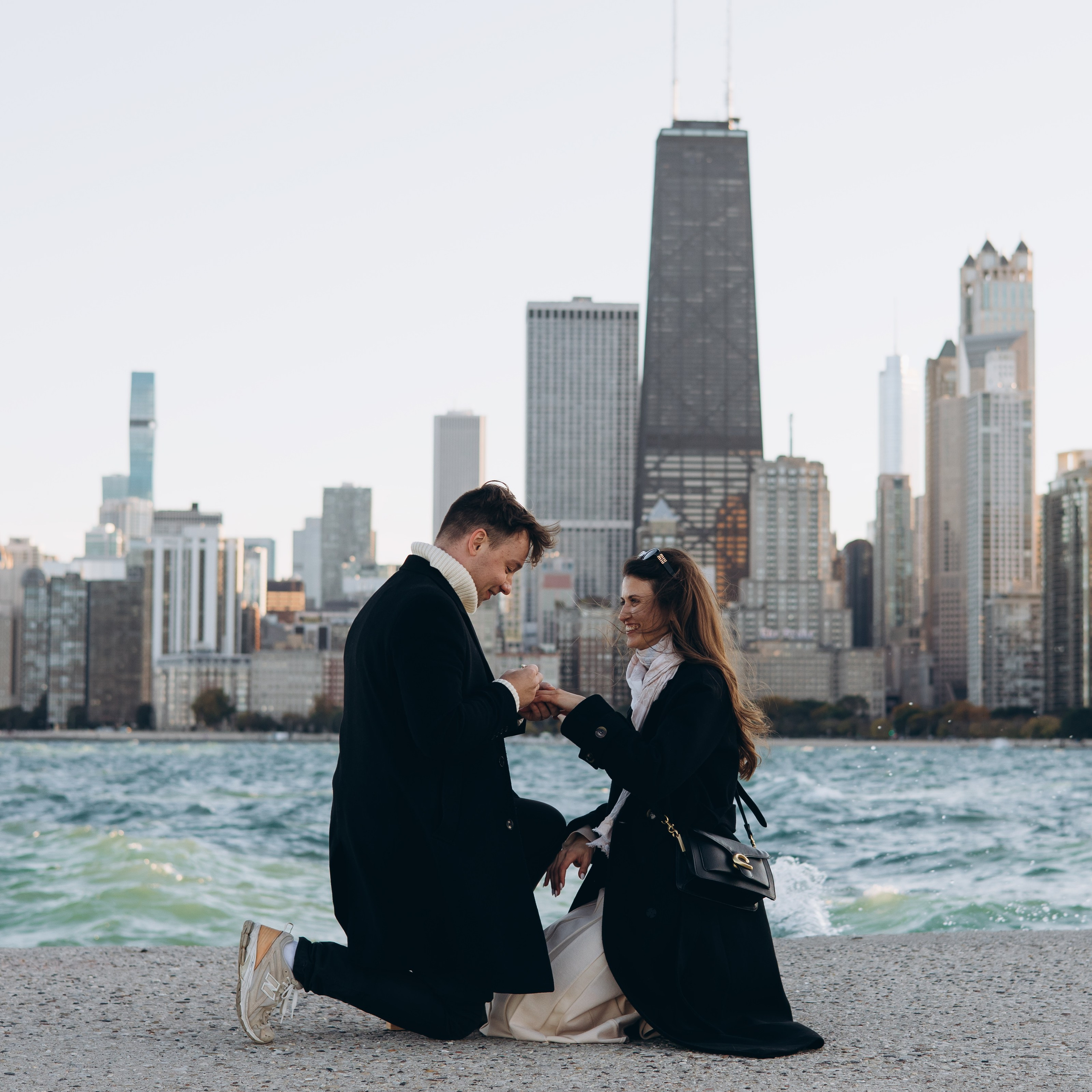 Engagement photo at North Avenue Beach Pier with a full Chicago skyline view.