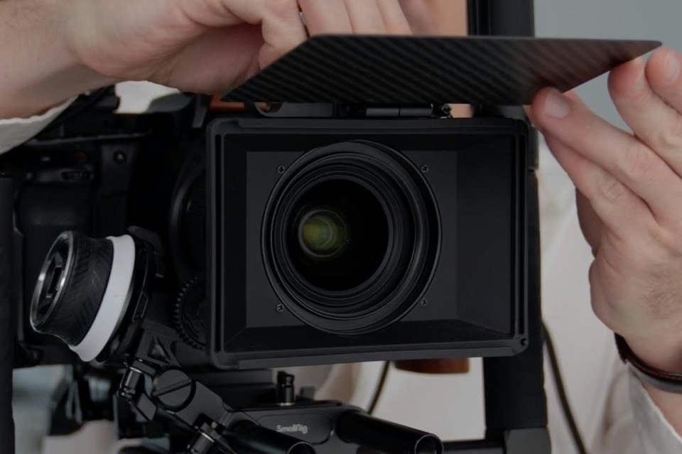 Videographer adjusting a professional cinema camera during a commercial shoot