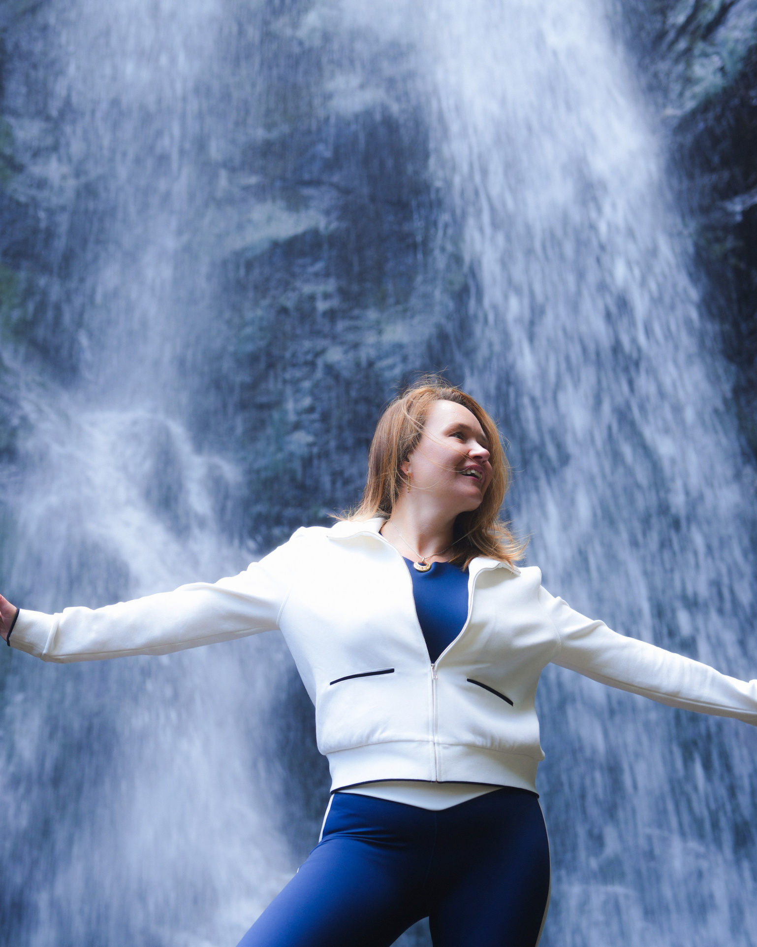 Outdoor portrait in Caucasus mountains during hike with Gveleti waterfall in the background.