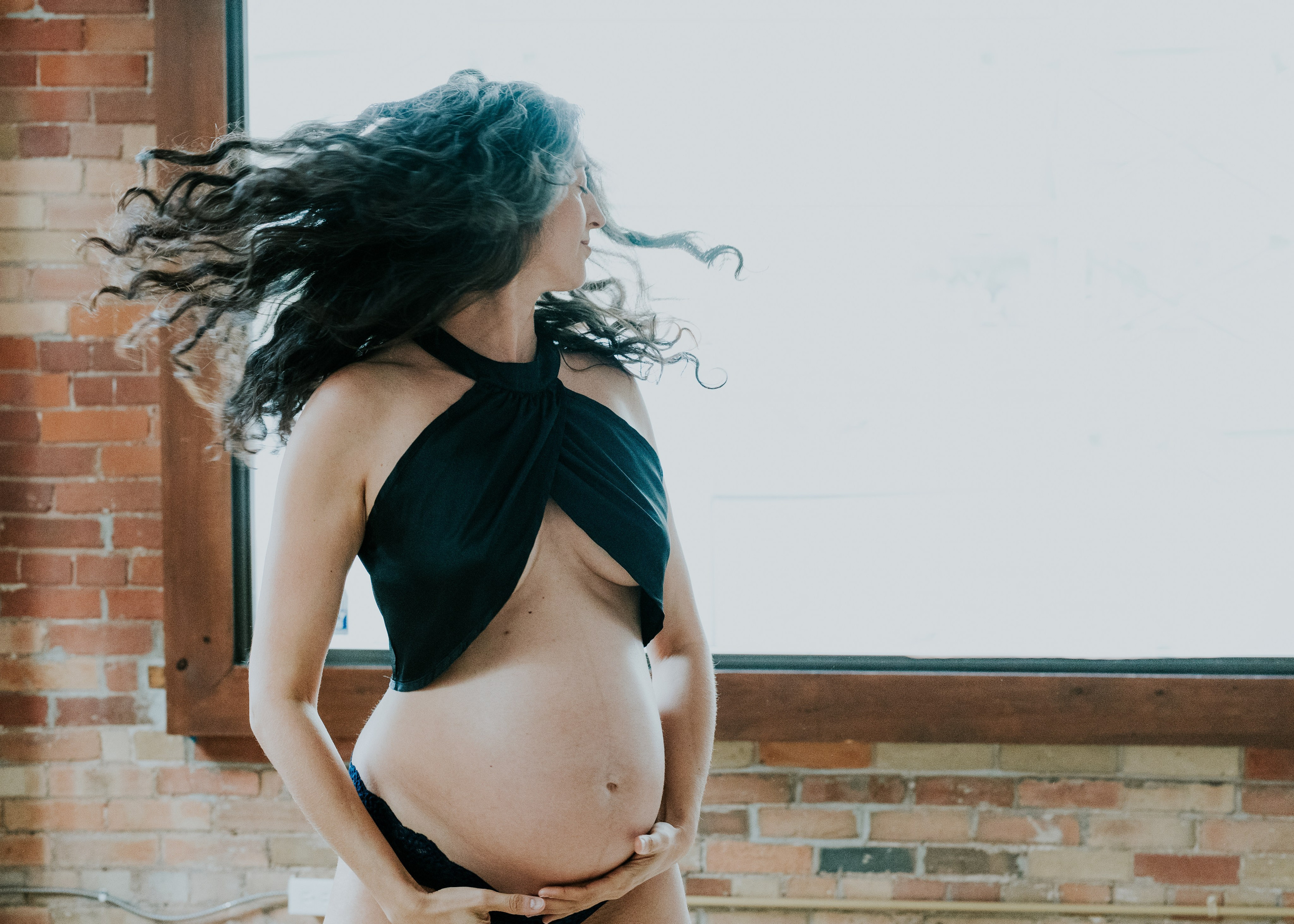 MATERNITY PHOTO OF WHITE WOMAN WITH BLACK CURLY HAIR 