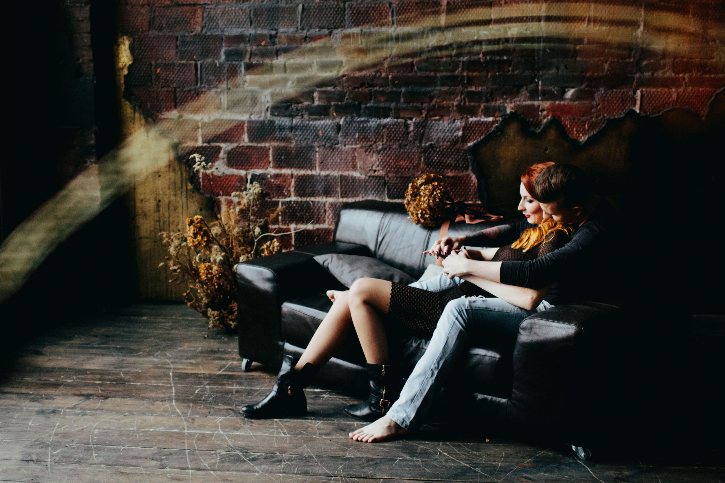 влюбленная пара обнимается на фоне фактурной кирпичной стены