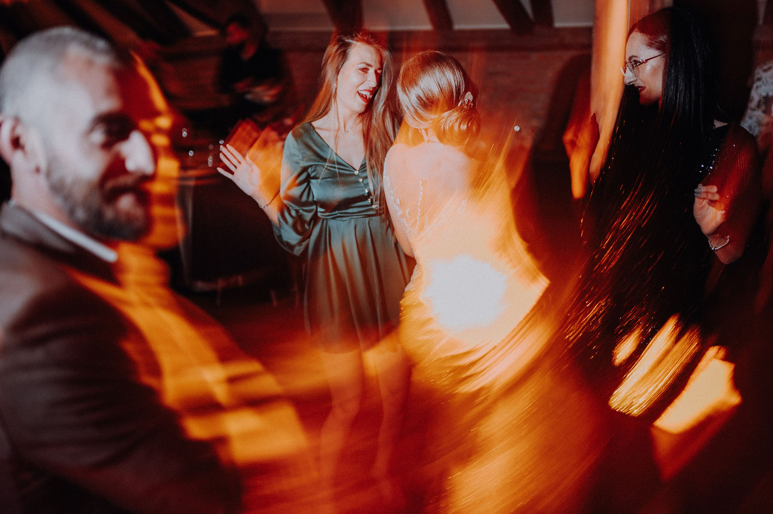 Invitați dansând energic la petrecerea de nuntă a Andreei și a lui Marius, fotografie cu efect de mișcare și lumini calde, Photosinteza