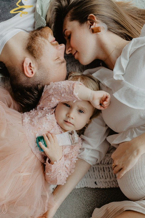 Сімейна фотографія батька матері і дитини які лежать на підлозі