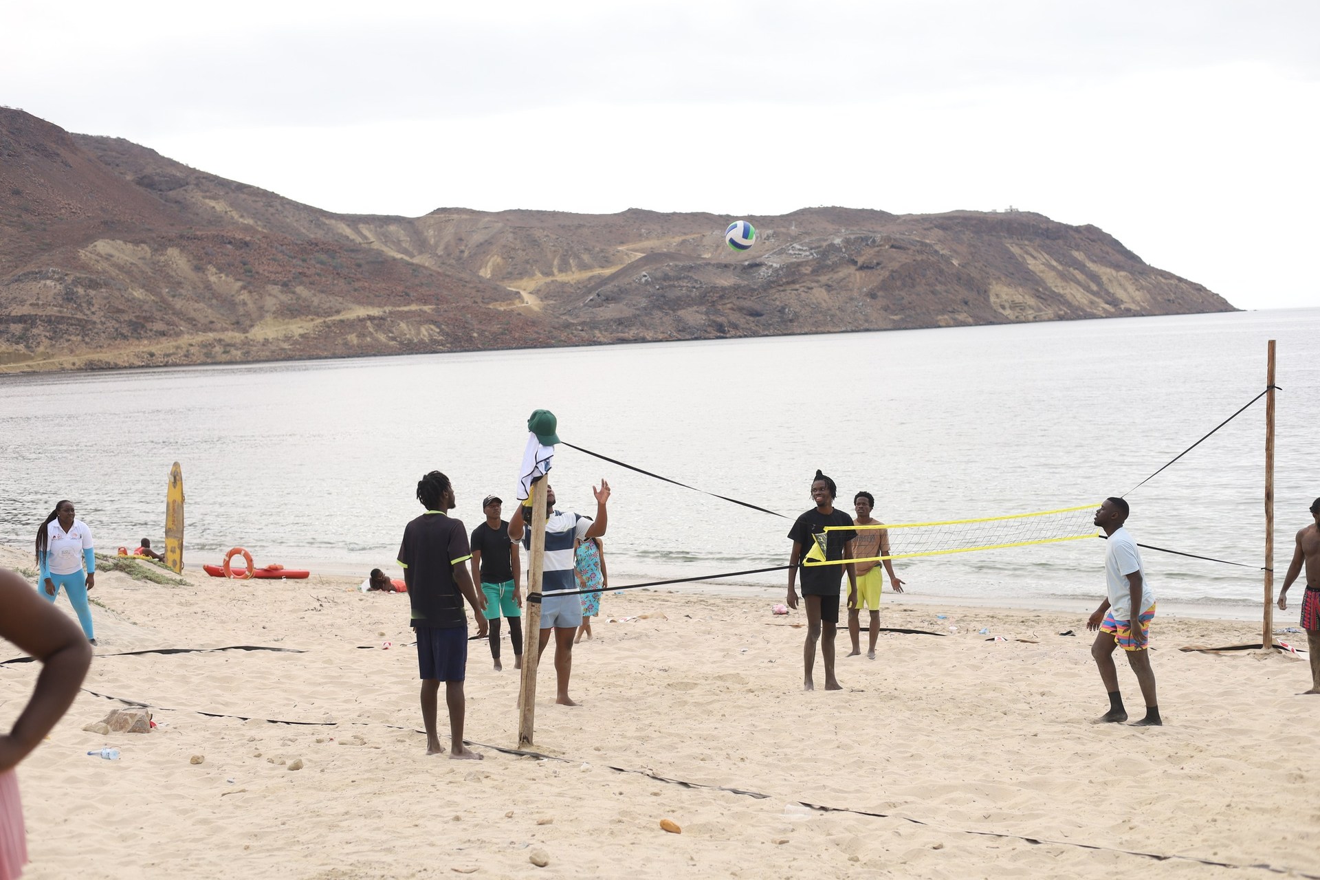 Jogo de voleibol na praia com a Baía dos Elefantes ao fundo