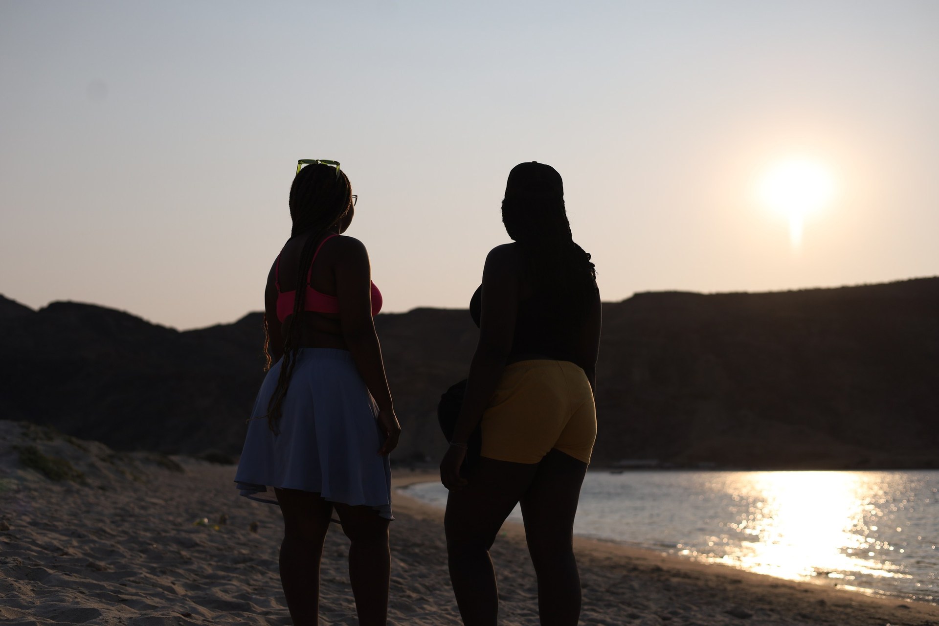 Silhuetas de participantes diante do pôr do sol na Baía dos Elefantes