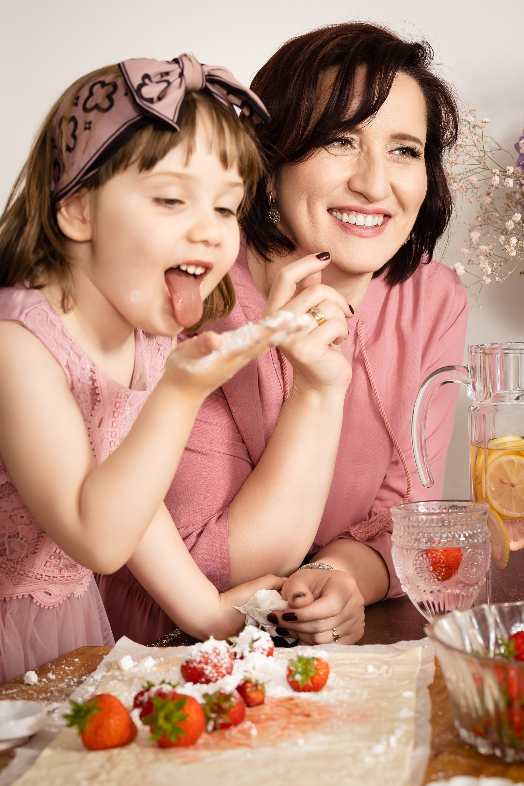 Eine vierköpfige Familie sitzt auf dem Boden vor einem Weihnachtsbaum und zeigt mit zwei Fingern der Hand das "FRIEDEN"-Zeichen.