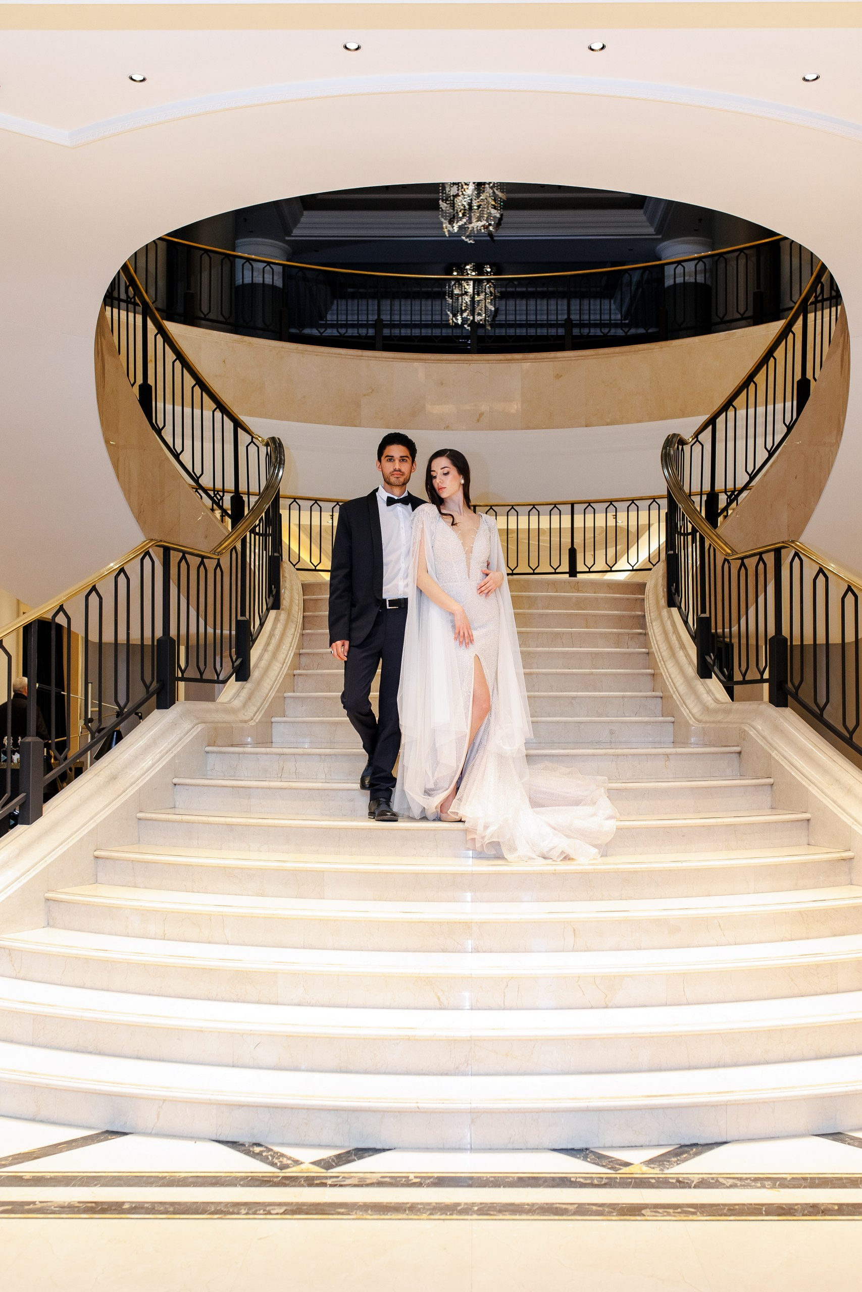 Elegantes Brautpaar auf der Marmorttreppe eines Berliner Luxushotels Ritz Carlton Berlin – Hochzeitsfotograf Berlin | Nataliia Schütze