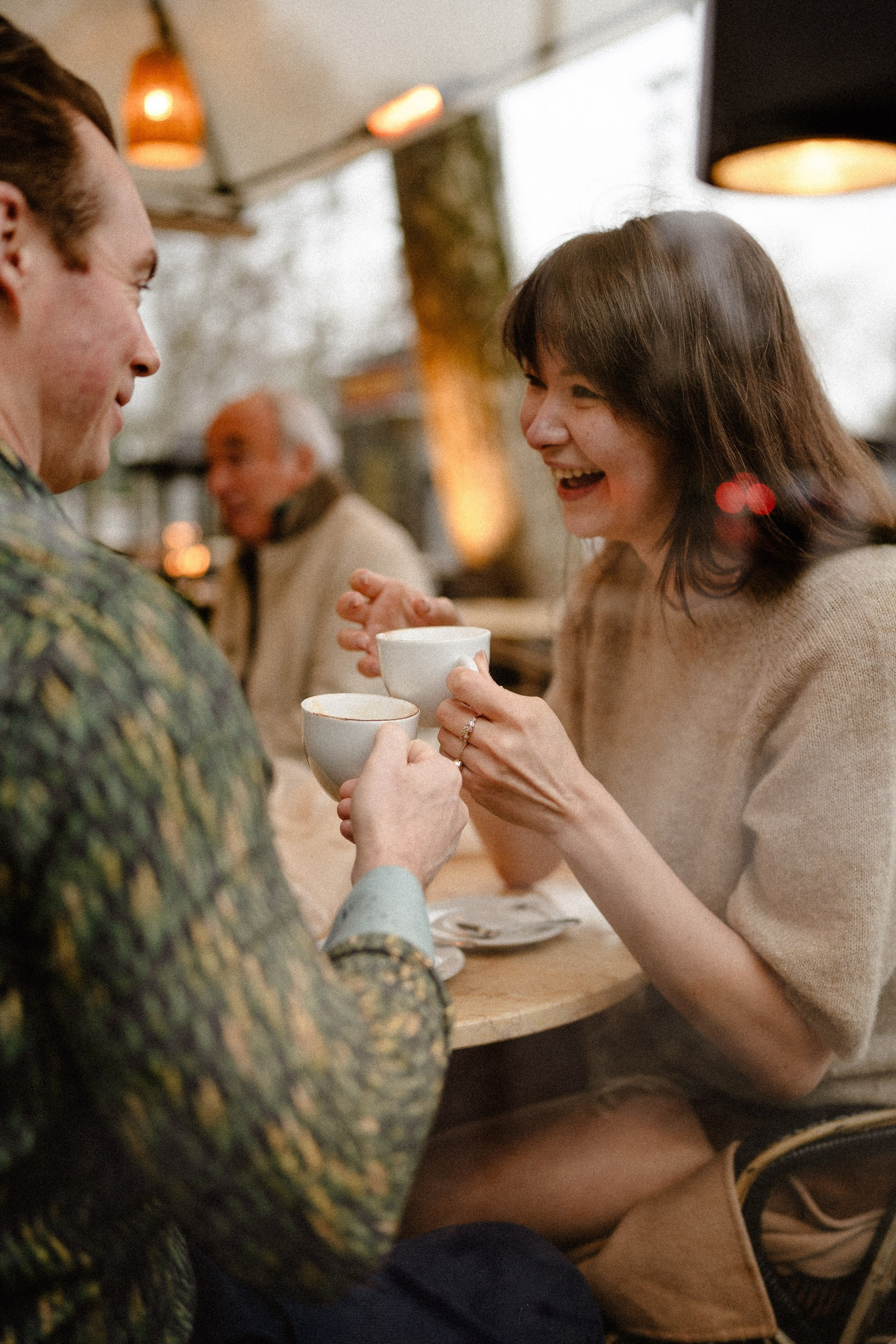 Couple laughing over coffee during a café date in Madrid