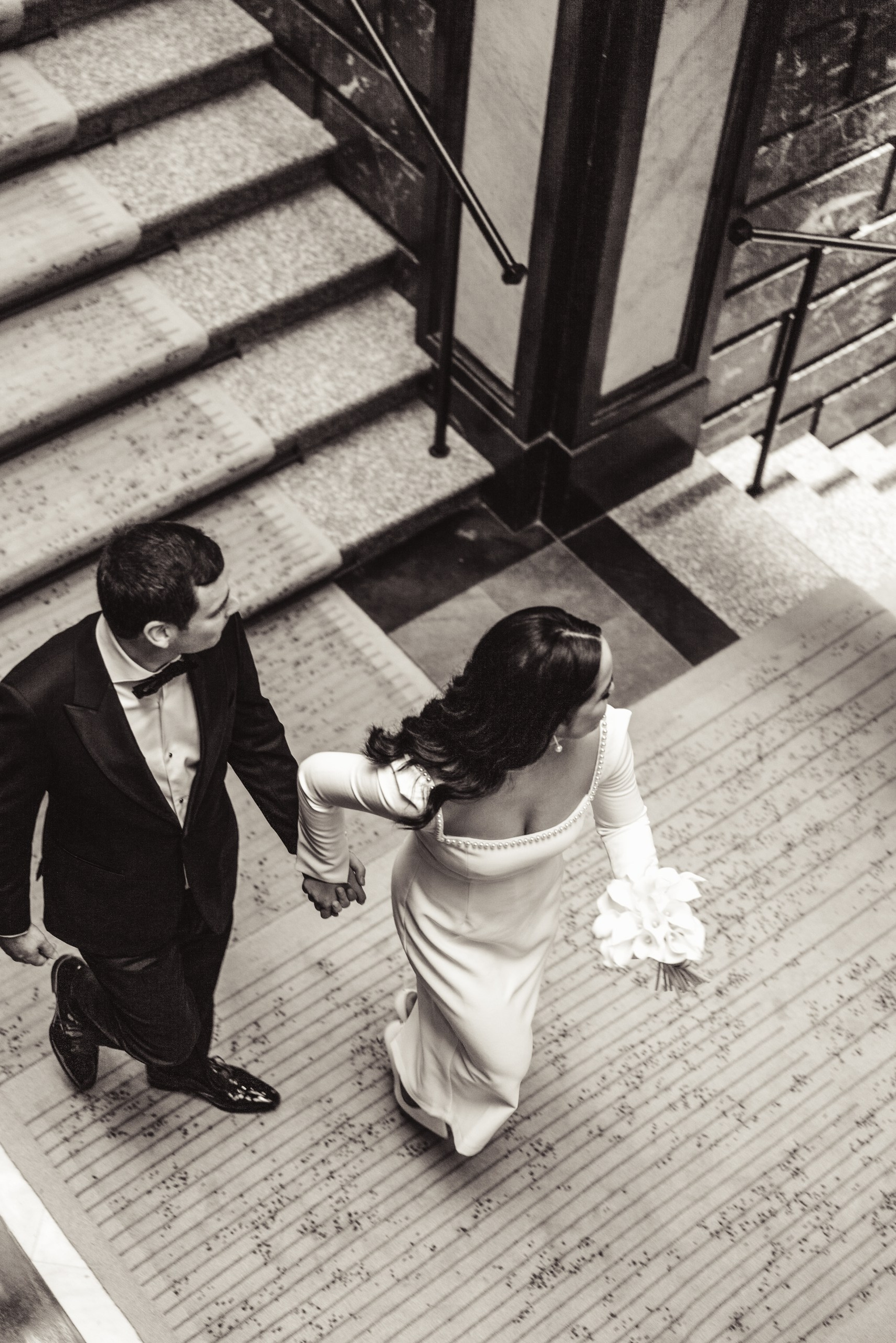 Het koppel loopt hand in hand op de trap bij het stadhuis van Antwerpen.