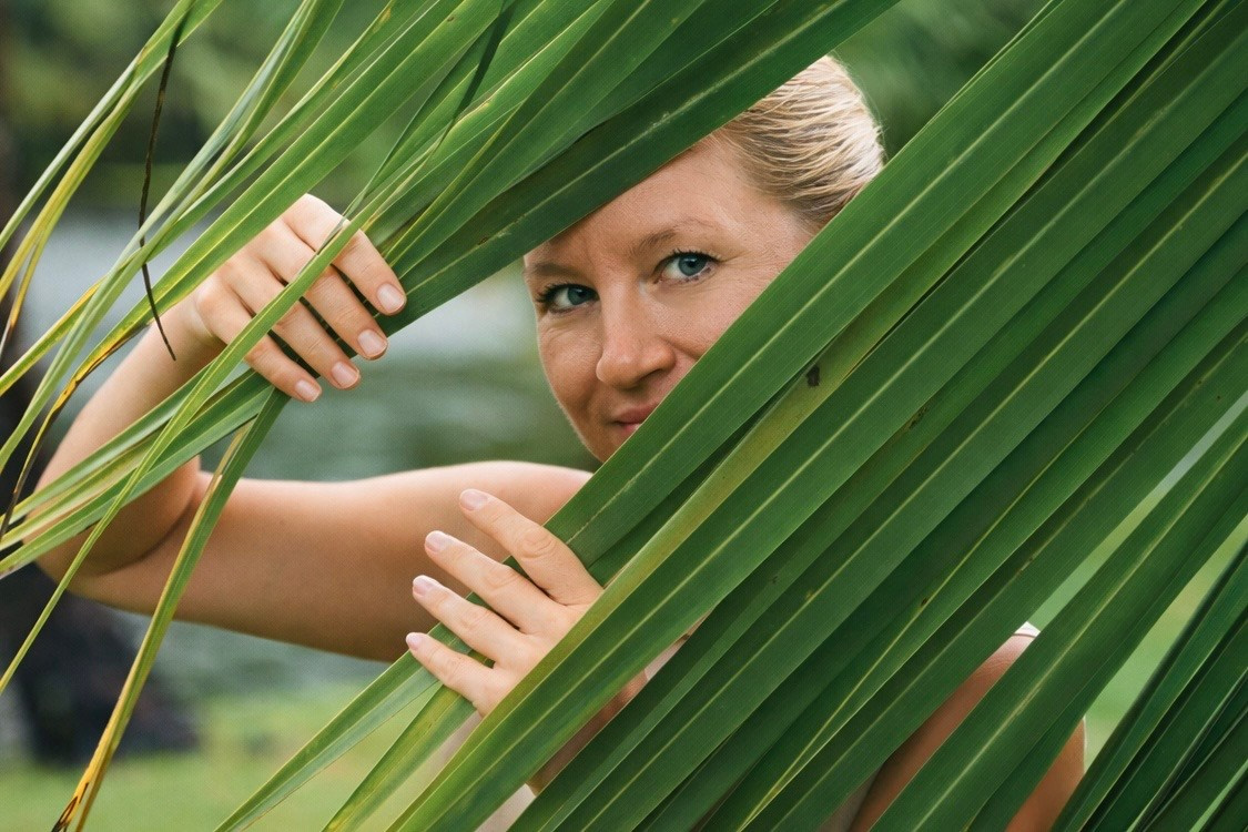 Irina Zoteeva artistic portrait photographer framed by tropical leaves, creative portrait photographer based in Solihull UK