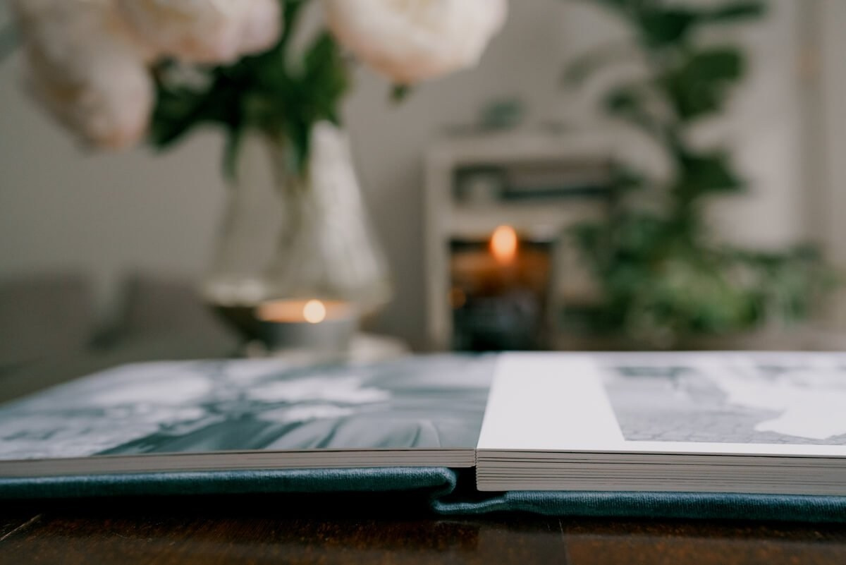Open wedding album with printed portraits on wooden table