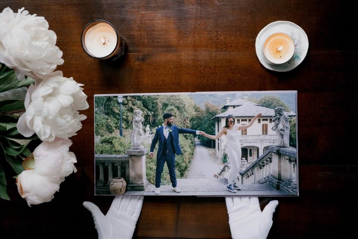 Wedding portraits spread inside album held with white gloves
