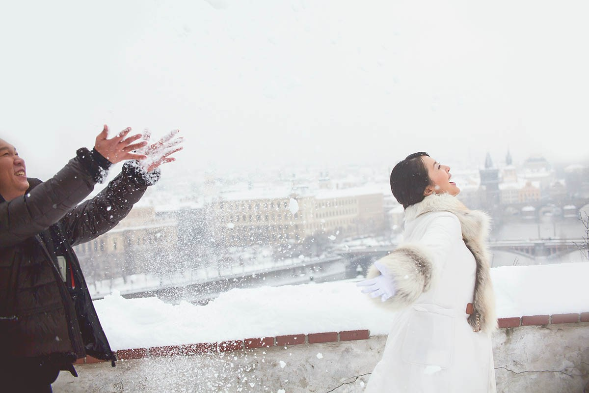 CY and Helen play in the snow above Prague during their winter pre-wedding.