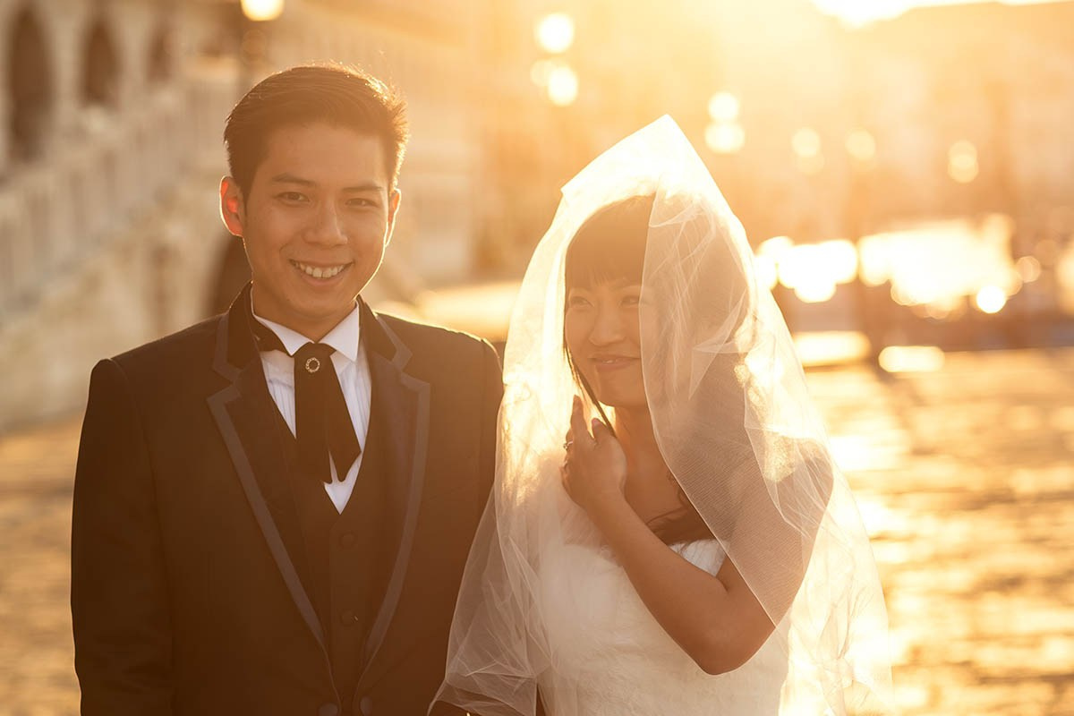 Smiling newlyweds are bathed in the golden hues of the early morning sunlight in Venice, Italy - Kurt Vinion Photography