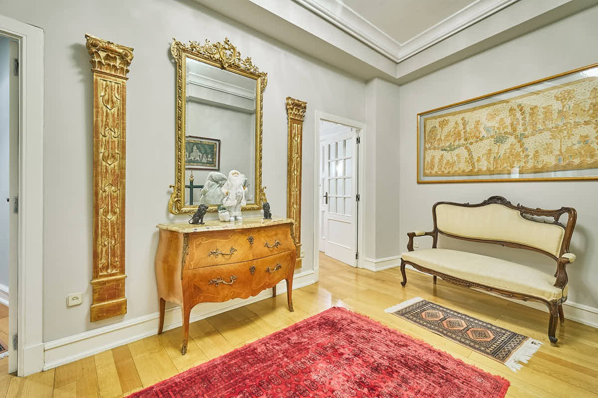 Recibidor clásico con muebles antiguos y espejo en un apartamento en Valencia
