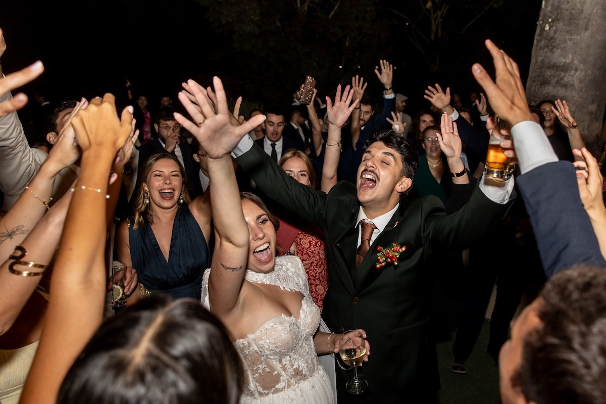 Bride and groom celebrating on the dance floor surrounded by guests at a destination wedding in Portugal