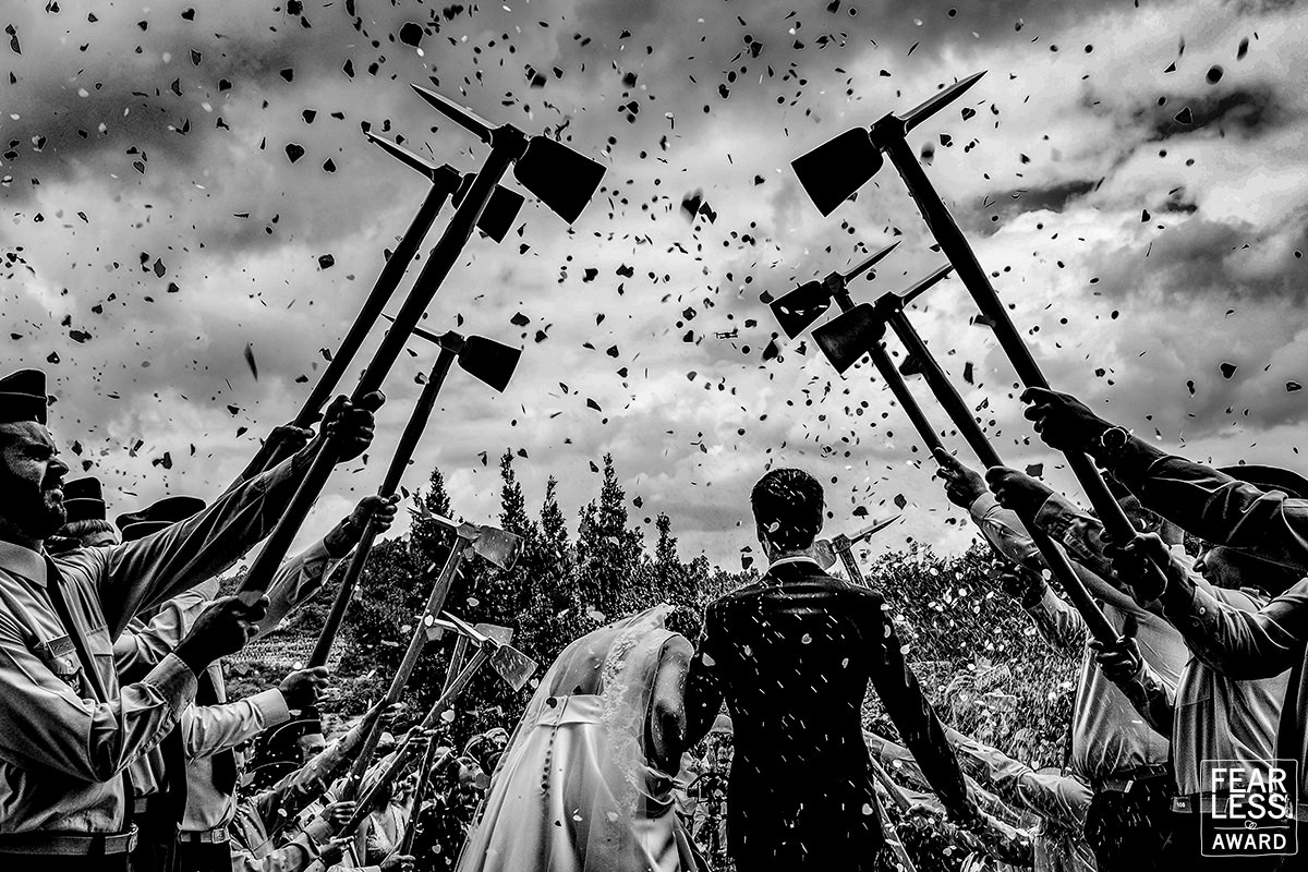 Bride and groom leaving church surrounded by confetti and firemen in Portugal