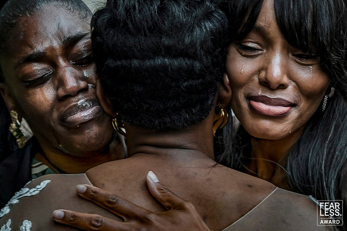 Emotional wedding guests embracing in tears during a destination wedding in Portugal