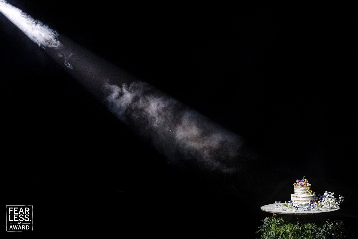 Wedding cake illuminated by a dramatic beam of light during a wedding reception