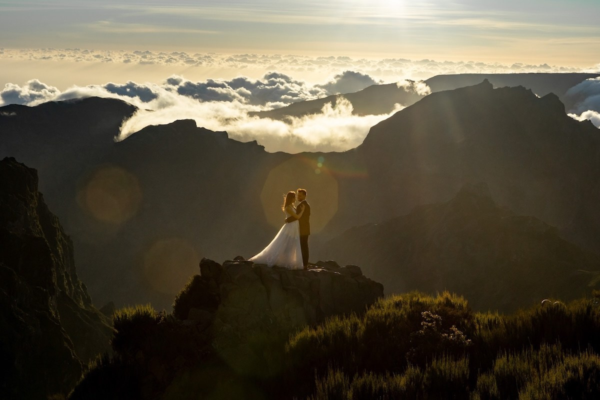 Newlyweds surrounded by mountains and golden light in Madeira during a destination wedding in Portugal