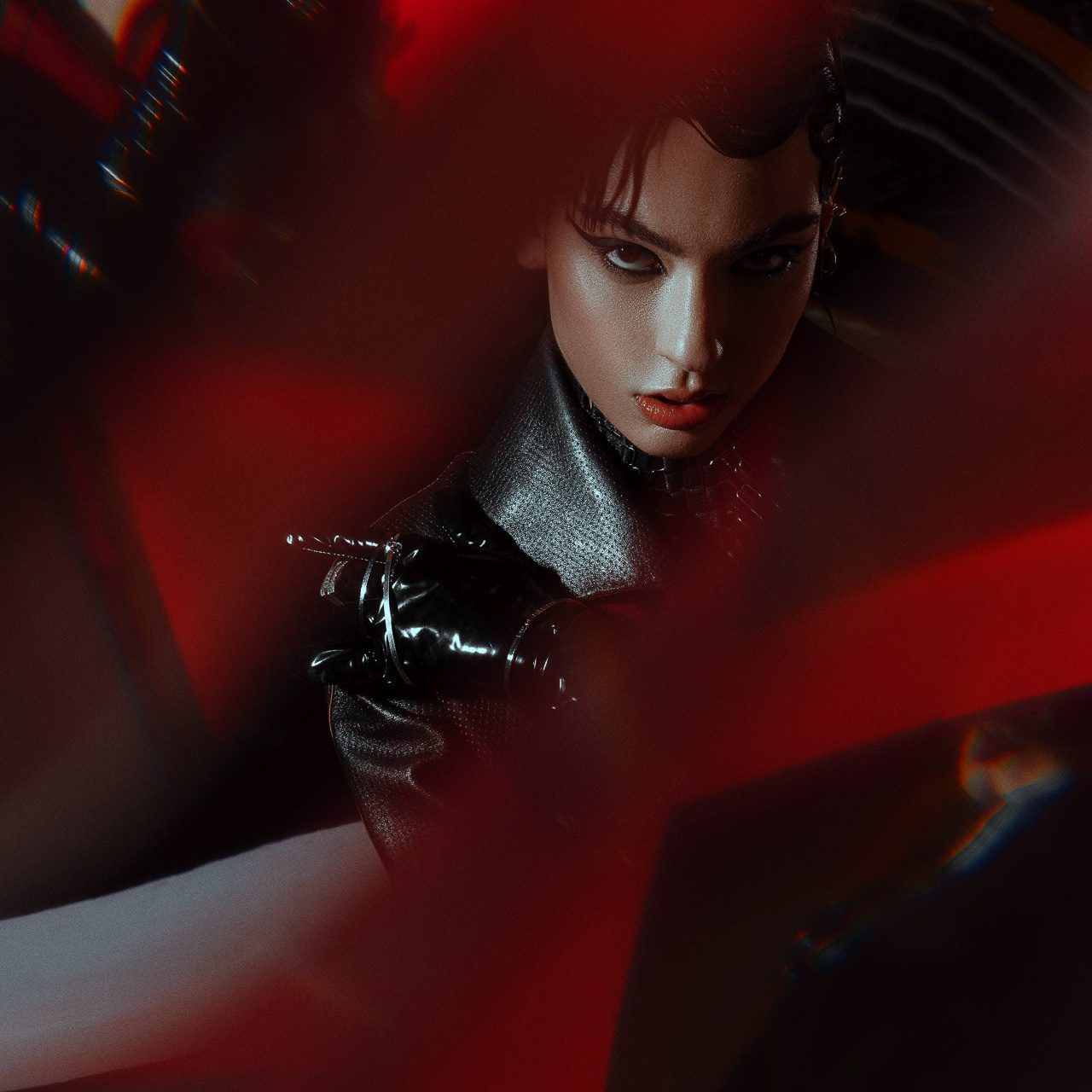 Dark fashion editorial portrait with dramatic red lighting and cinematic mood