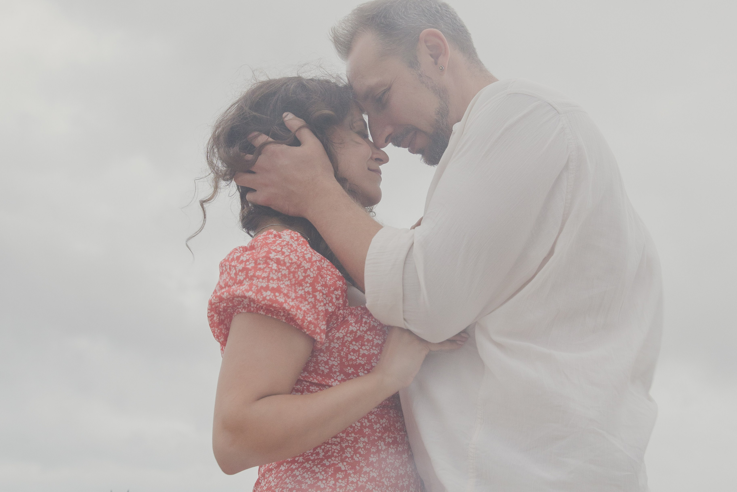 A romantic photograph of a couple embracing each other in the sky.