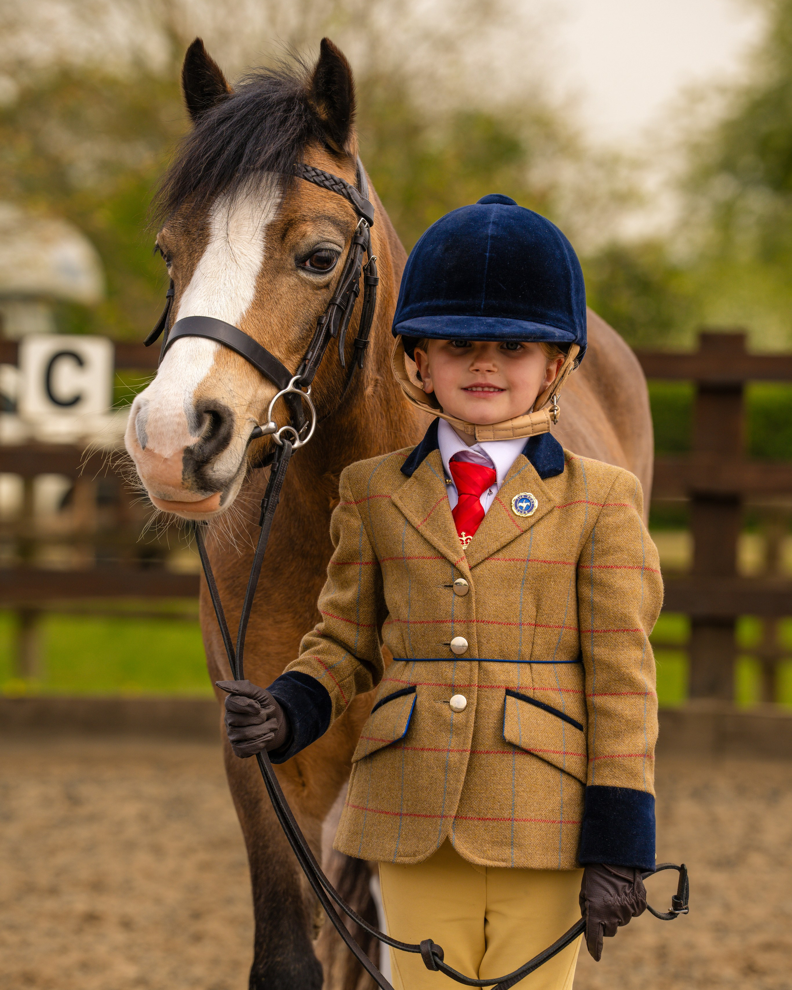 Young rider leading horse in smart equestrian attire before a show