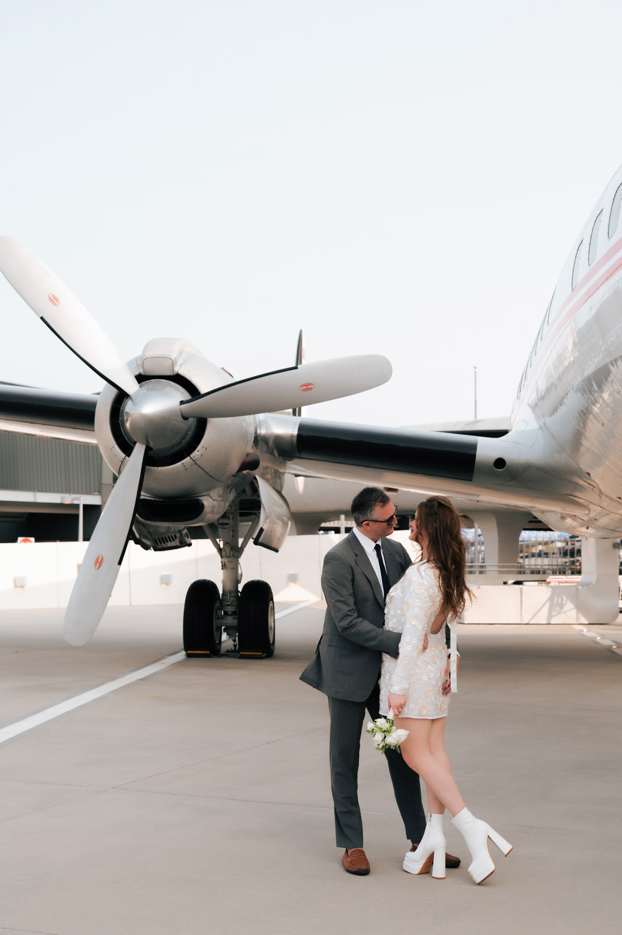 a couple standing in front of a plane