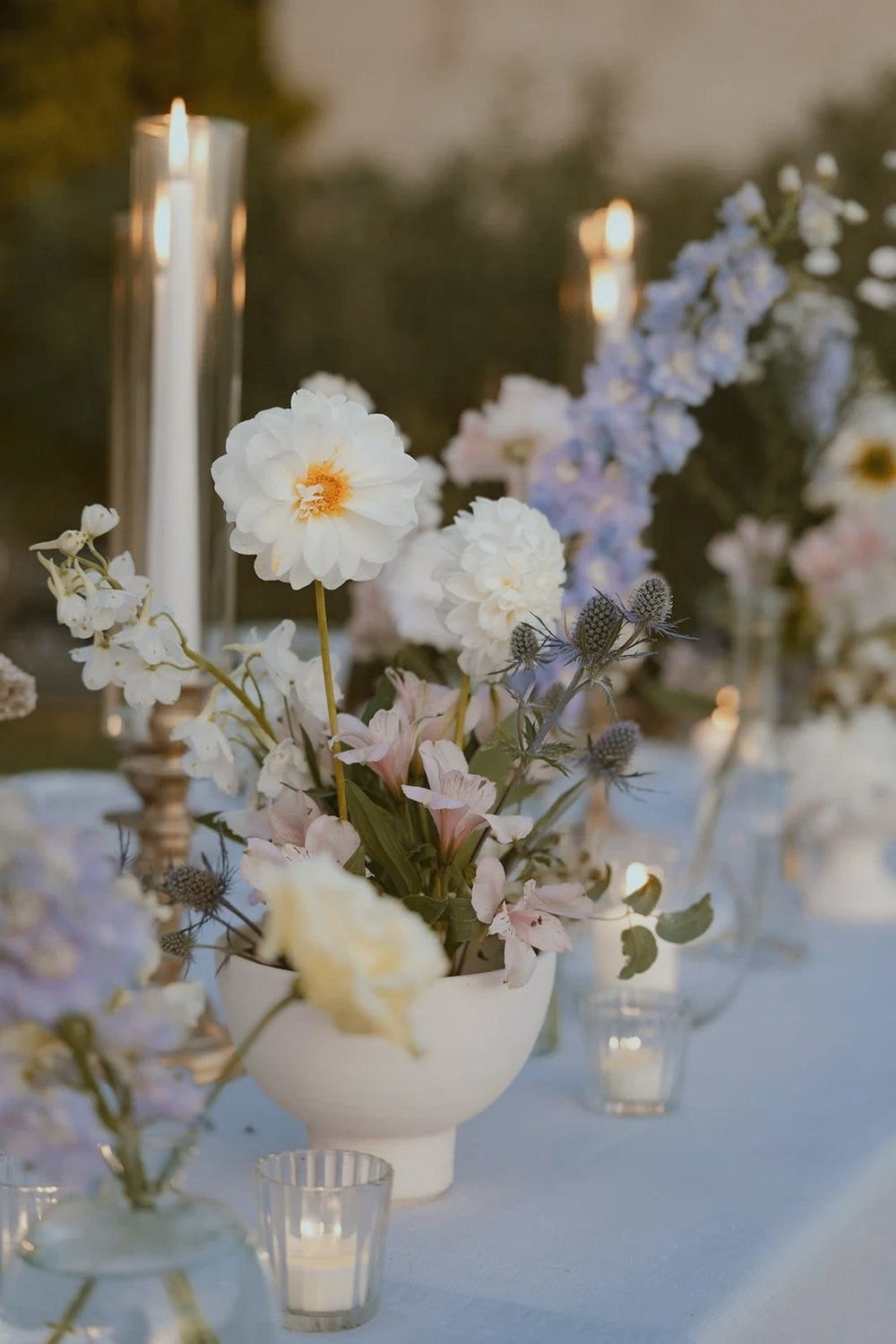 Pastel flowers in glass vases on dinner table