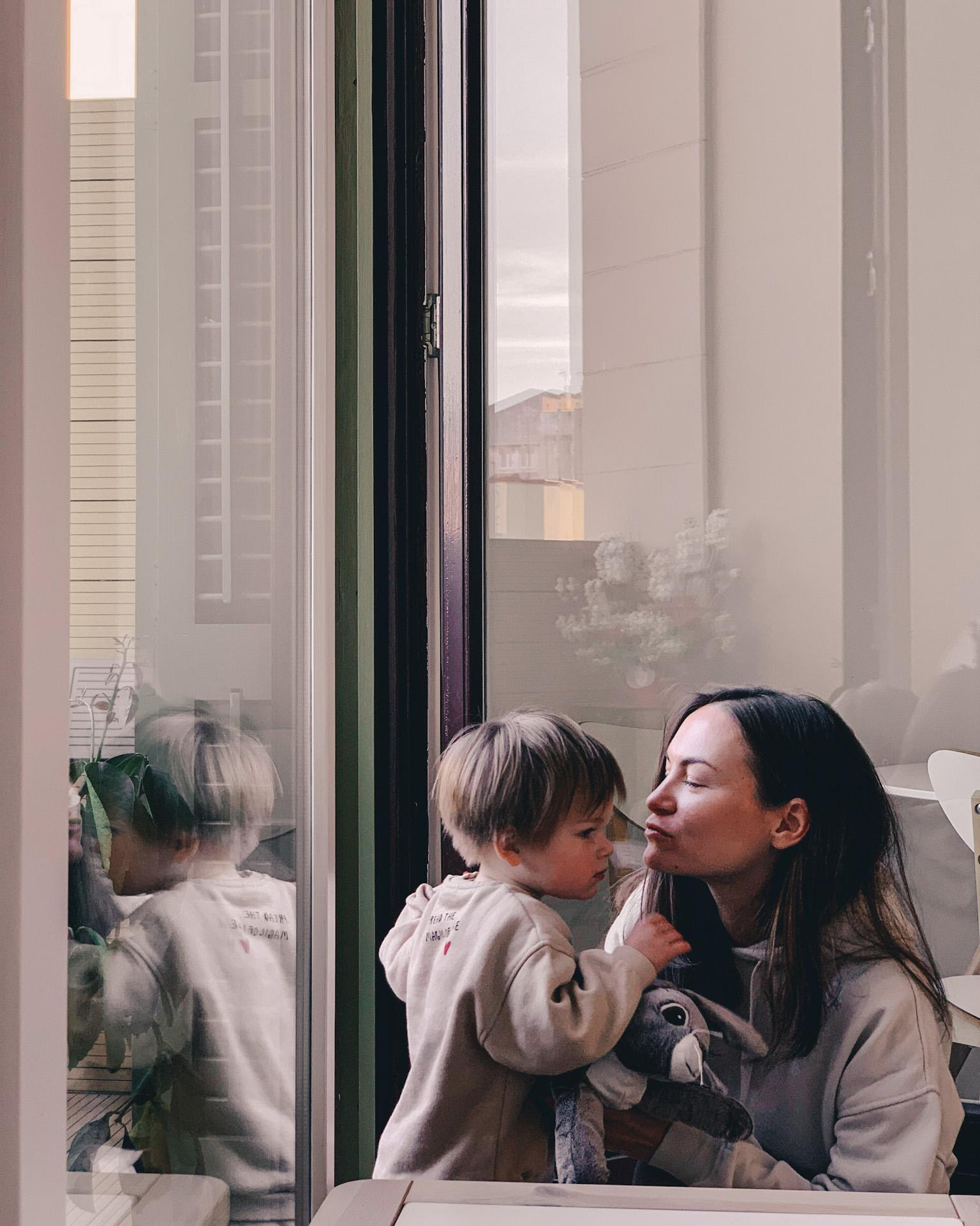 Mum is kissing the little girl. Online photo shoot.