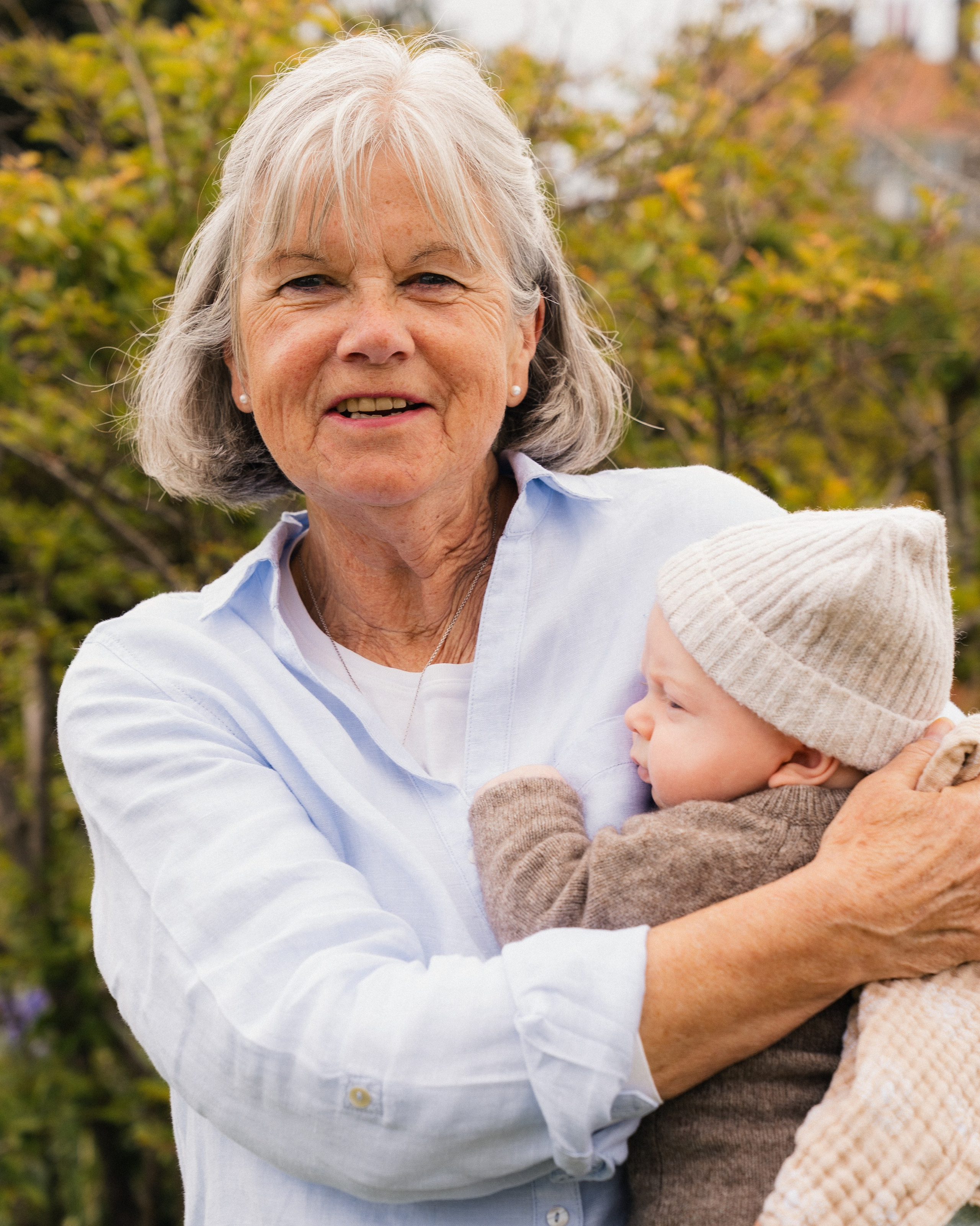 Grandmother cuddling her grandchild during a multi-generational family photography session in Alnwick, Northumberland.