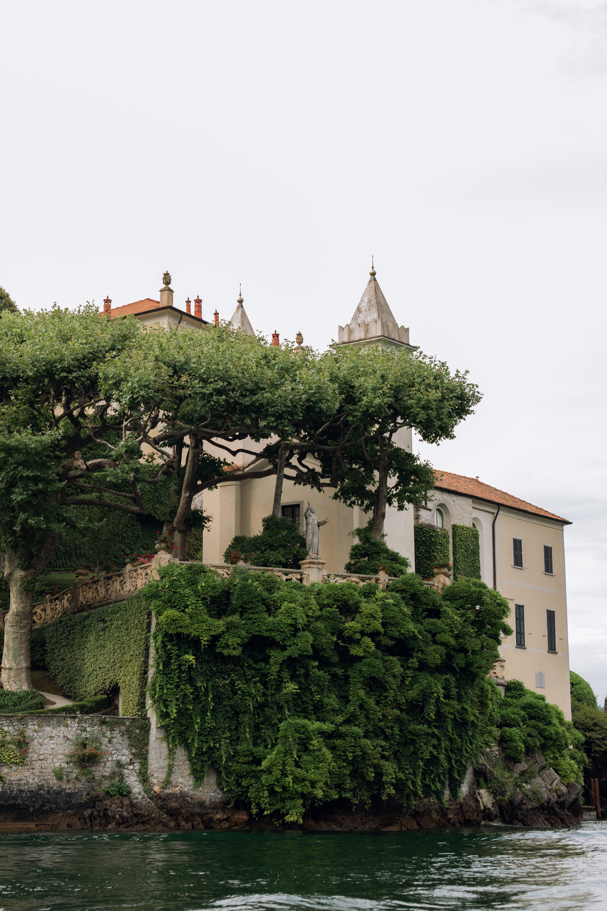 a house on a small island with a tree growing on top