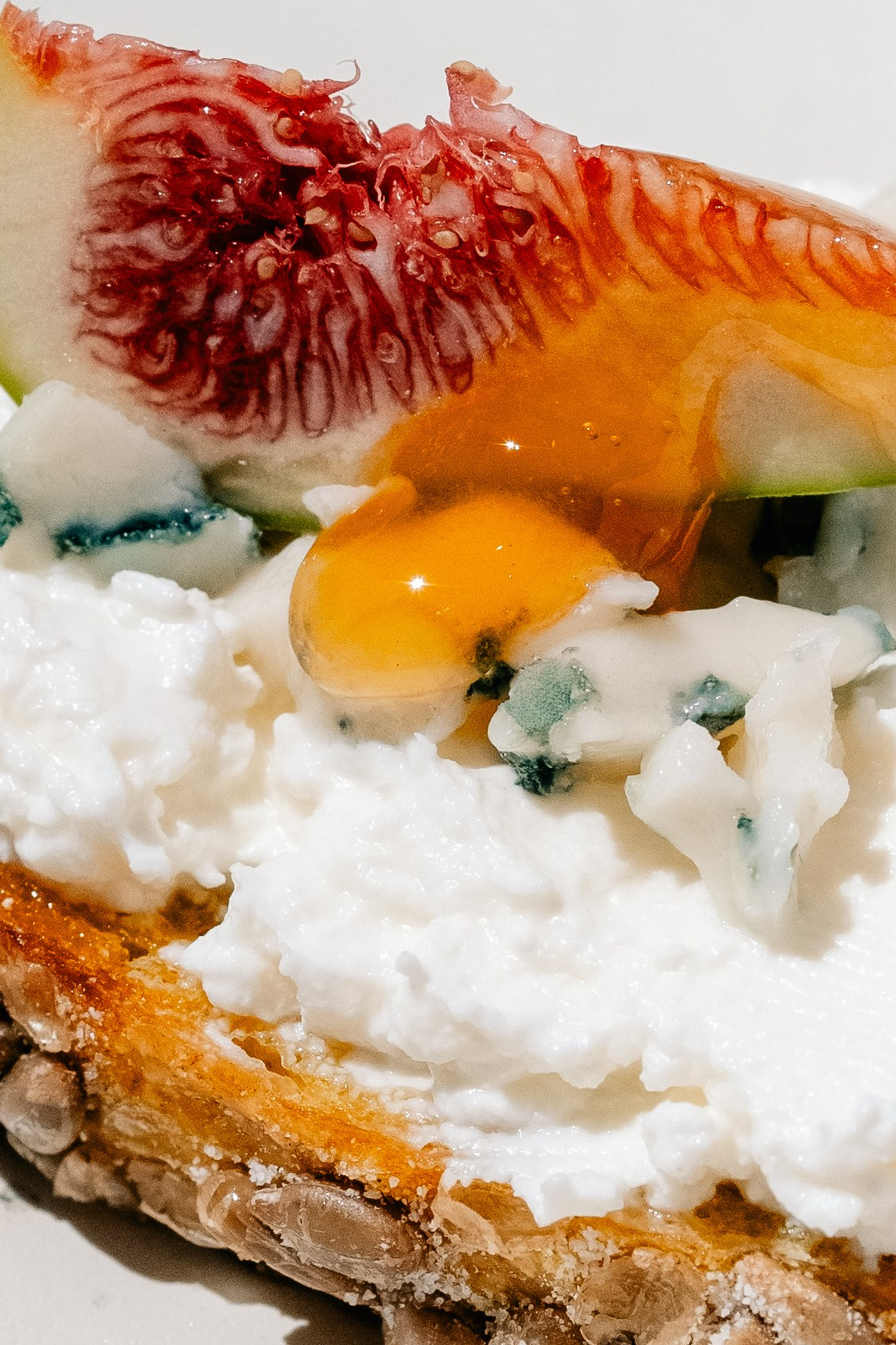 Cheese and fig open sandwich with a honey drop