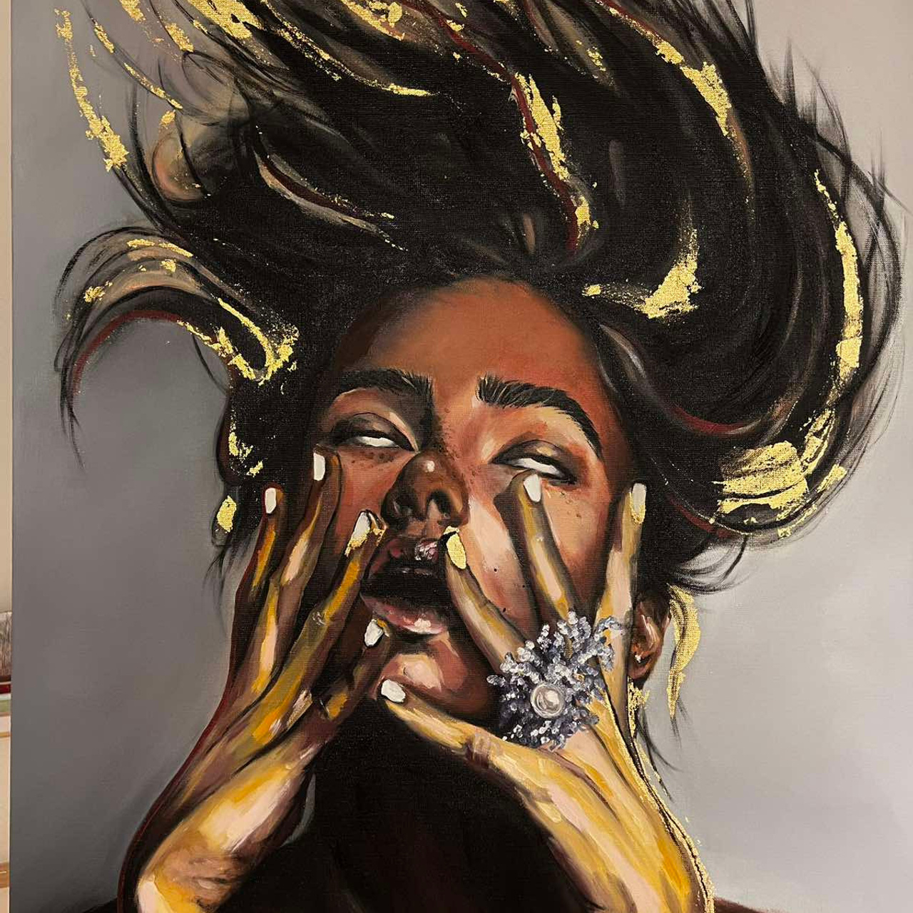 Лицо девушки с волосами наверх с кистями рук длинными пальцами и крупным кольцом