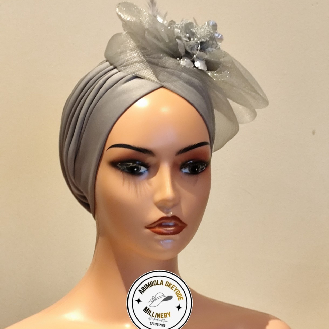 Pleated turban with attached fascinators.