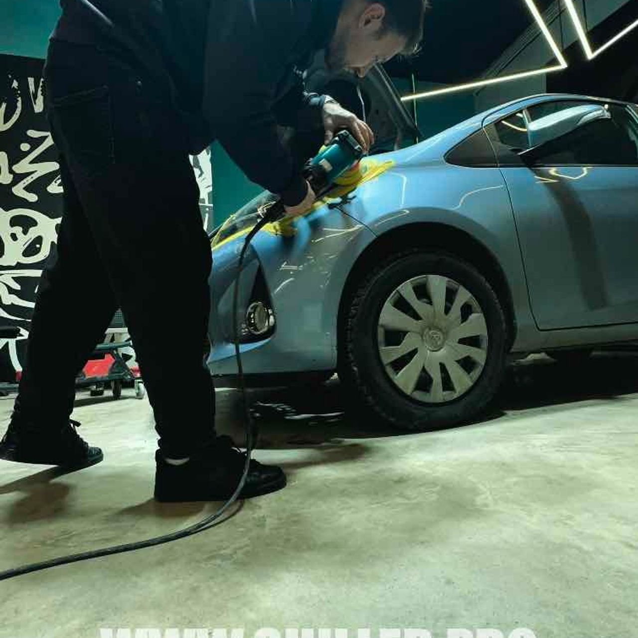 Мастер  выполняет тщательный детейлинг автомобиля в мастерской. полировка фар 