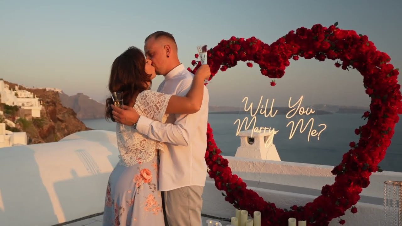Surprise Marriage Proposal in Santorini at Sunset | Oia Cliffs 2025. Photographe vidéaste à Santorin|Séances photos de Robe volante Santorin|