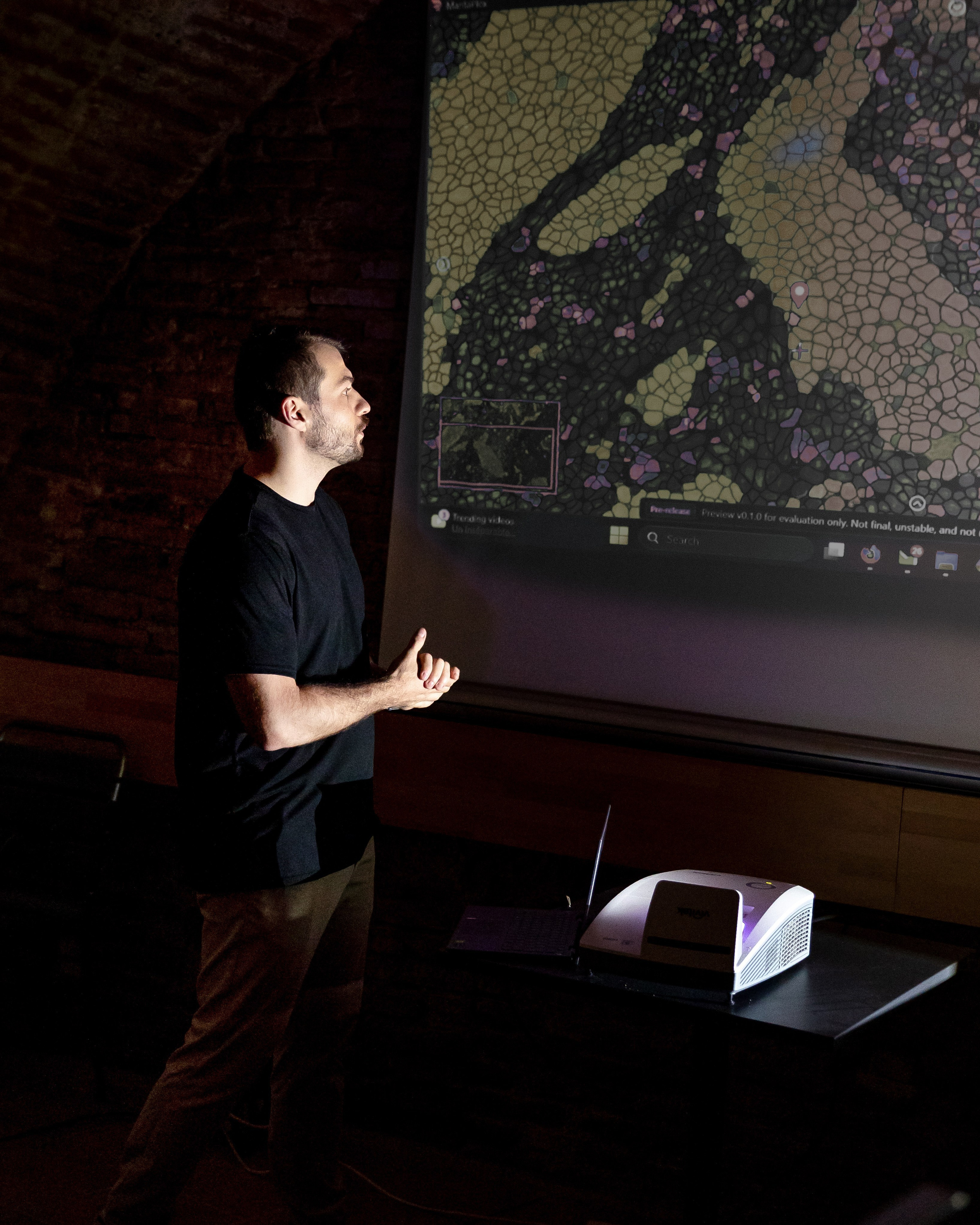 speaker presenting in front of a screen during a business event